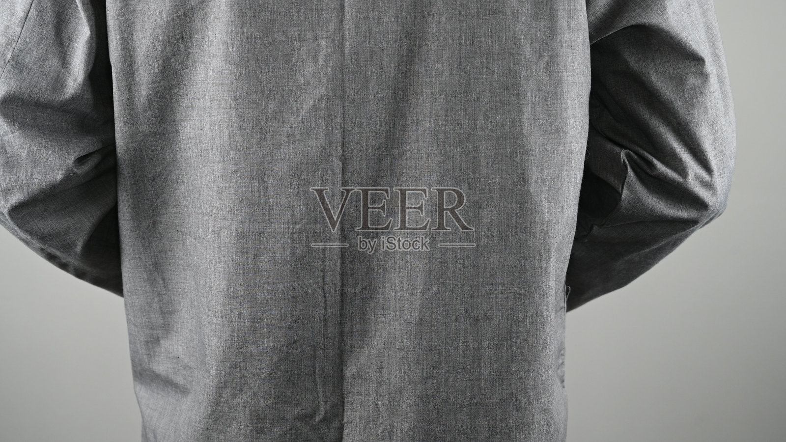 穿着灰色睡衣的男人，背景是灰色照片摄影图片