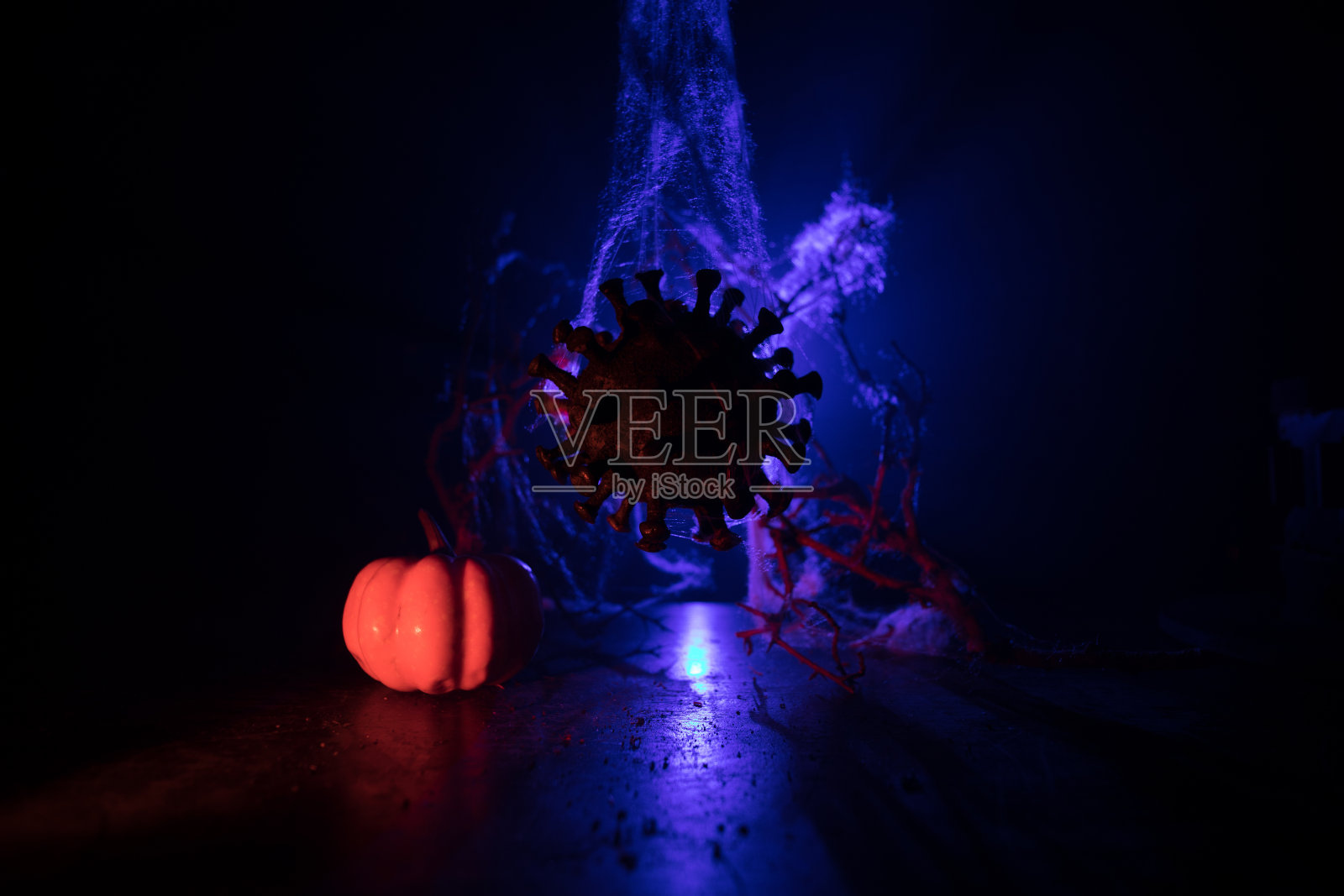 万圣节期间冠状病毒全球流行概念。发光的南瓜和Covid小说的黑暗与主题幽灵装饰。万圣节南瓜在雾背光。照片摄影图片