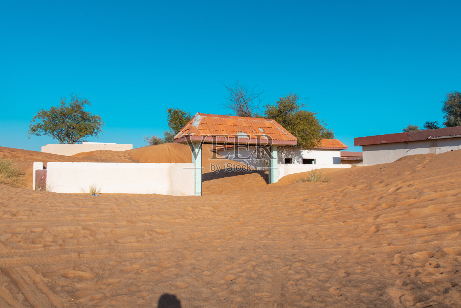 阿联酋迪拜附近的沙漠中被沙丘吞噬的废弃房屋照片摄影图片