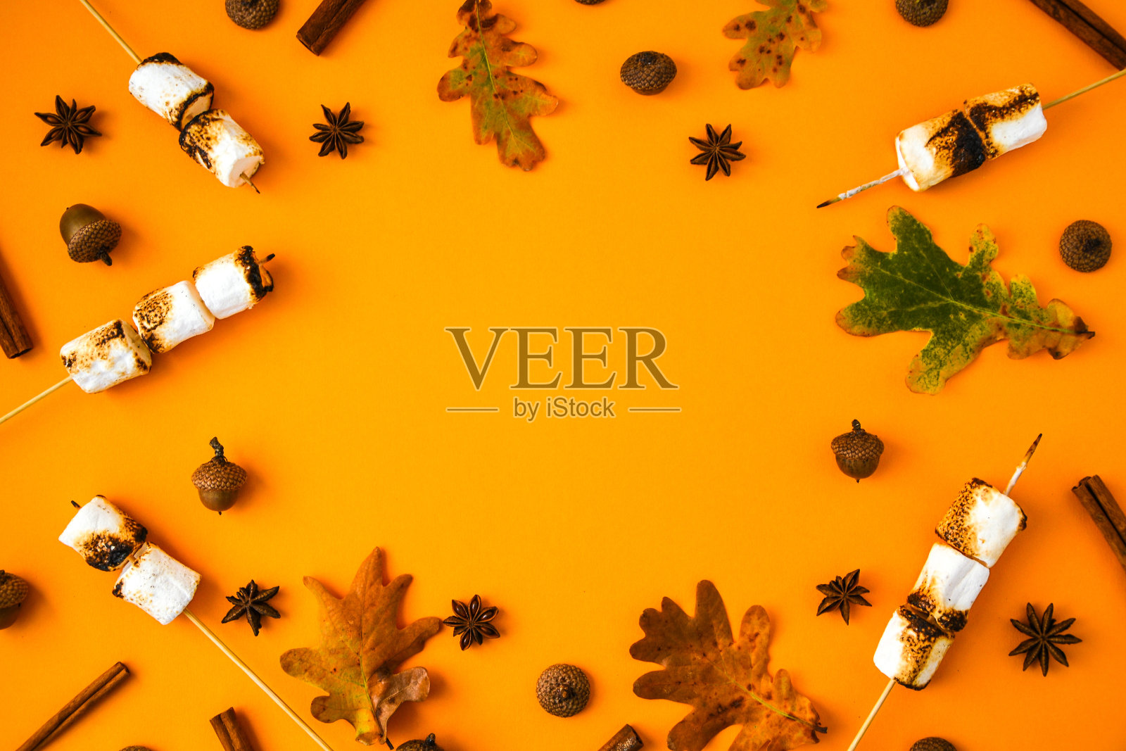 圣诞组成。肉桂棉花糖叶子和茴香在黄色的背景。秋天组成。感恩节的点缀。秋季框架与复制空间照片摄影图片