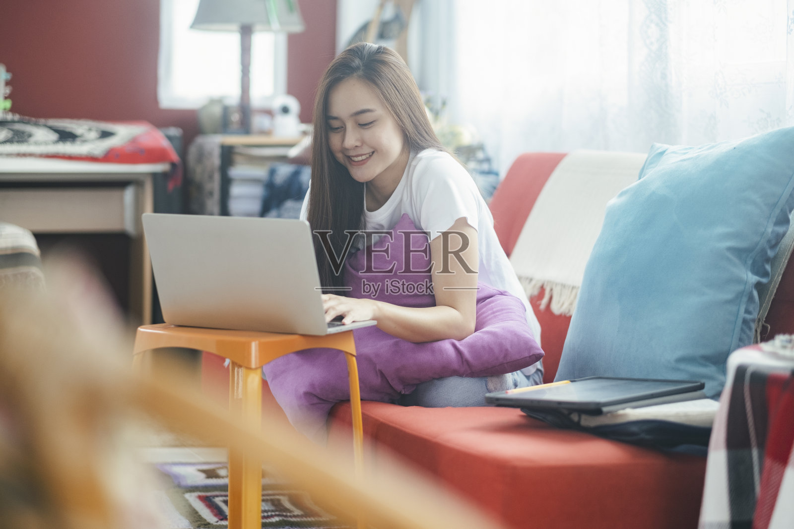 迷人的年轻亚洲女性在家工作。照片摄影图片