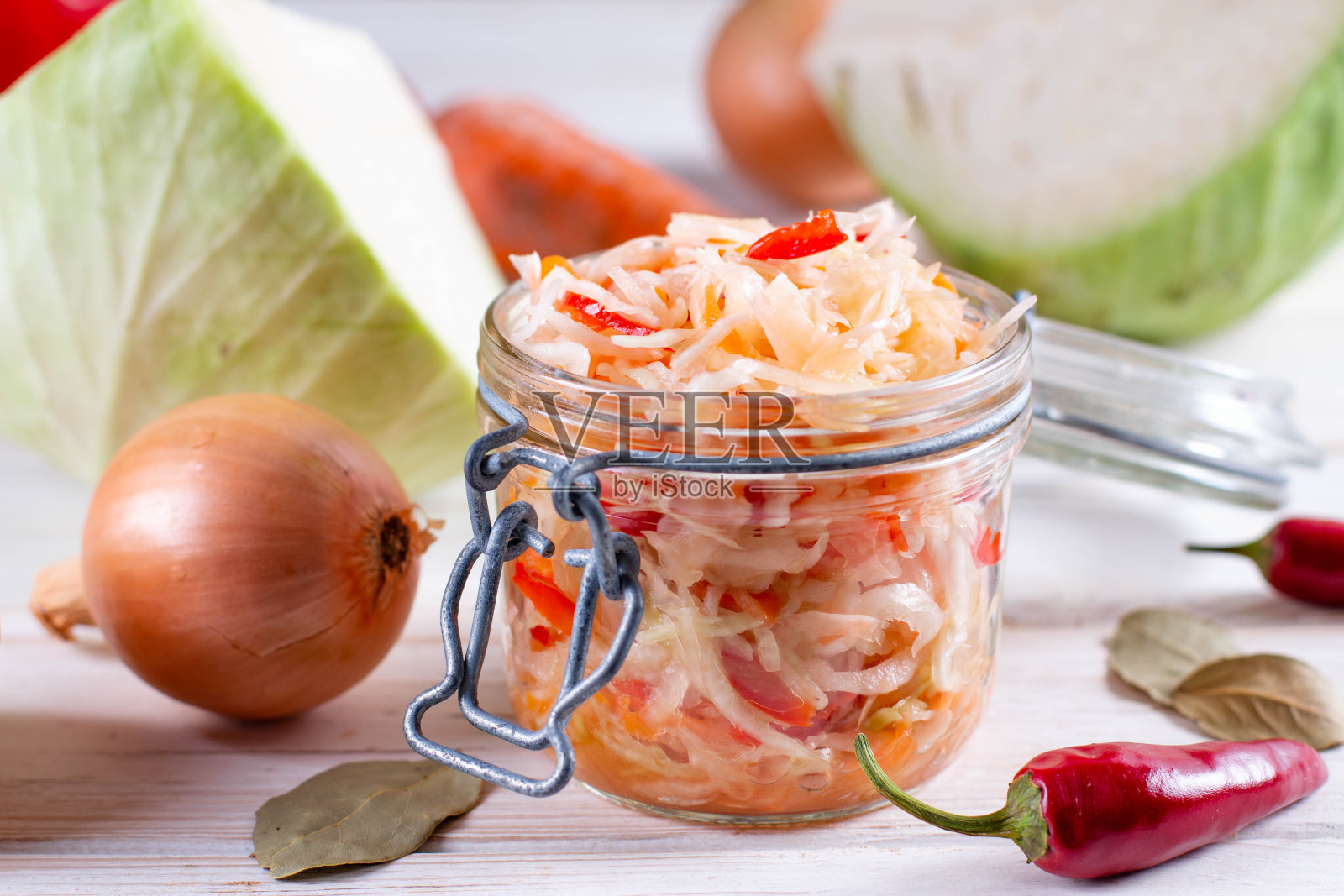 木桌上放着自制酸菜的玻璃瓶。照片摄影图片