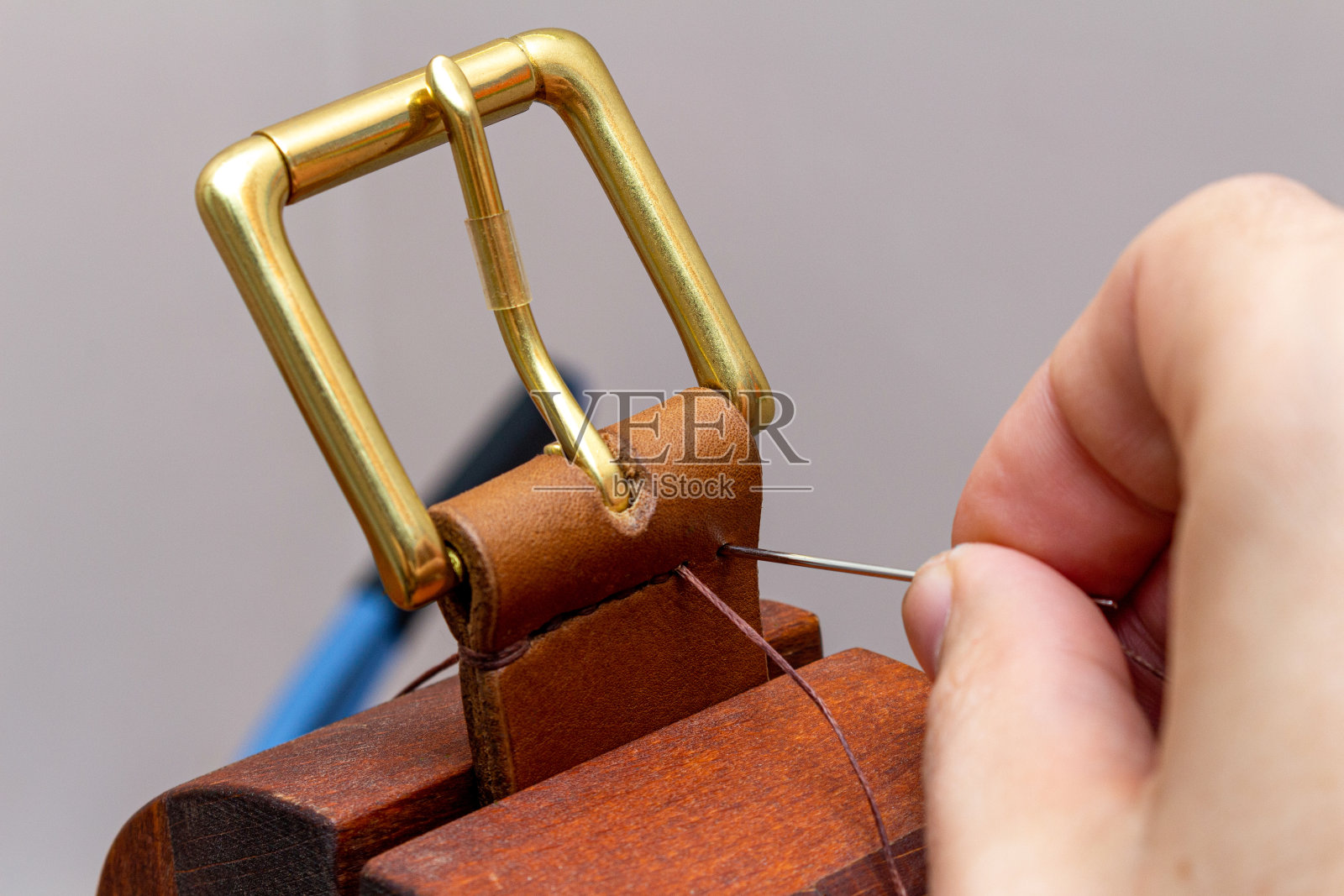 用手针线缝制手工制作的棕色皮带照片摄影图片