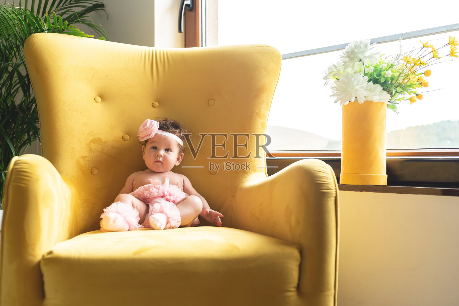 小女孩坐在家里的扶手椅上照片摄影图片