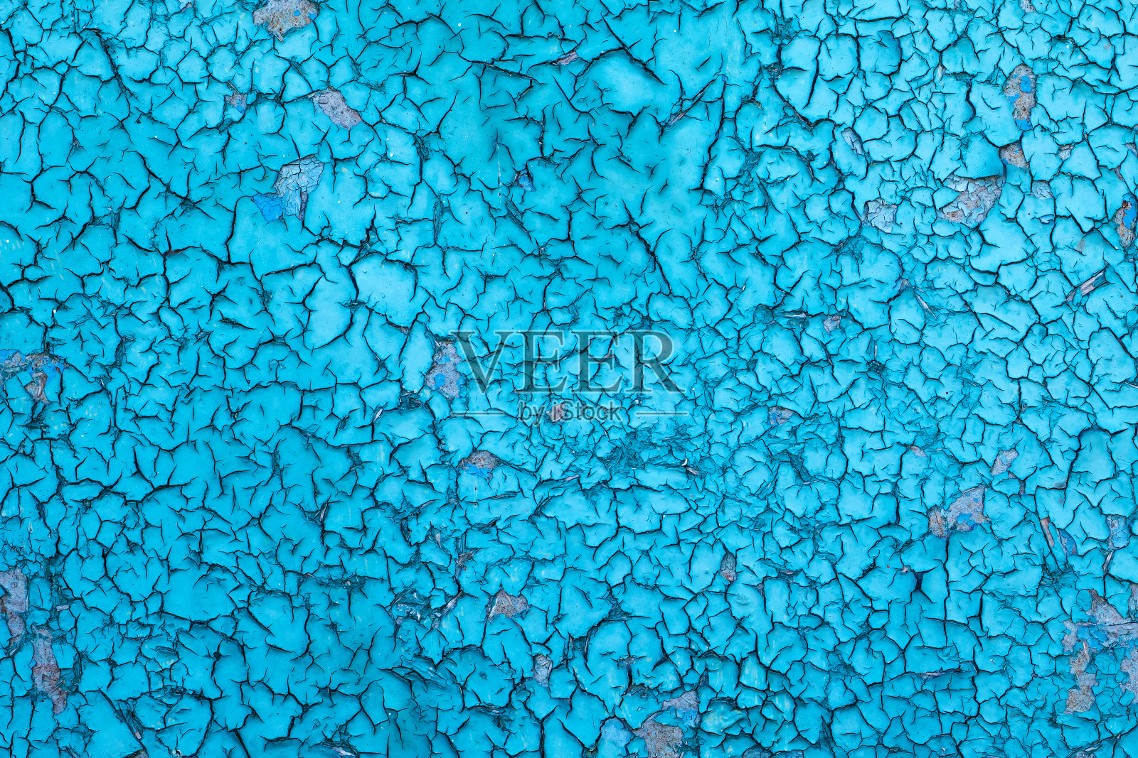 旧的油性蓝色底漆被天气弄裂了。纹理照片摄影图片
