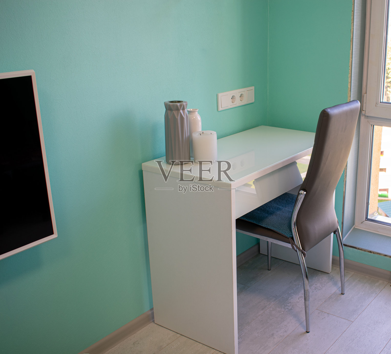 绿色墙壁背景上的花瓶木制化妆桌。房间角落靠窗的桌子和椅子。照片摄影图片