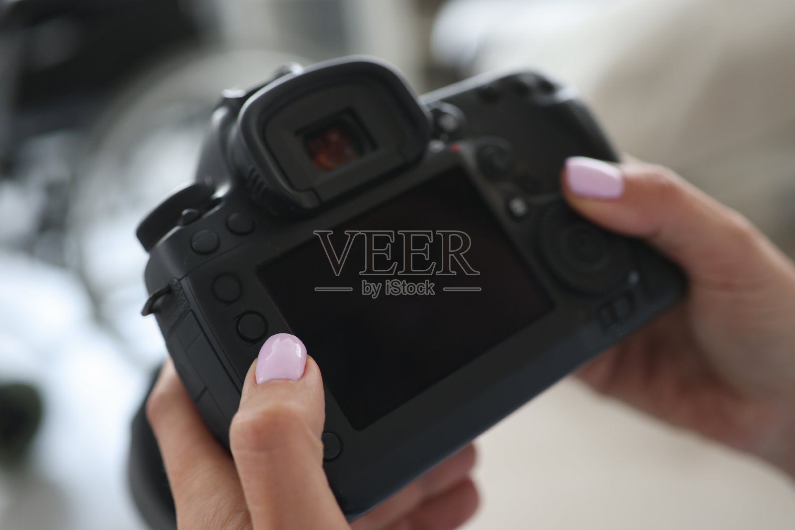 在摄影棚里，女性的手拿着相机照片摄影图片