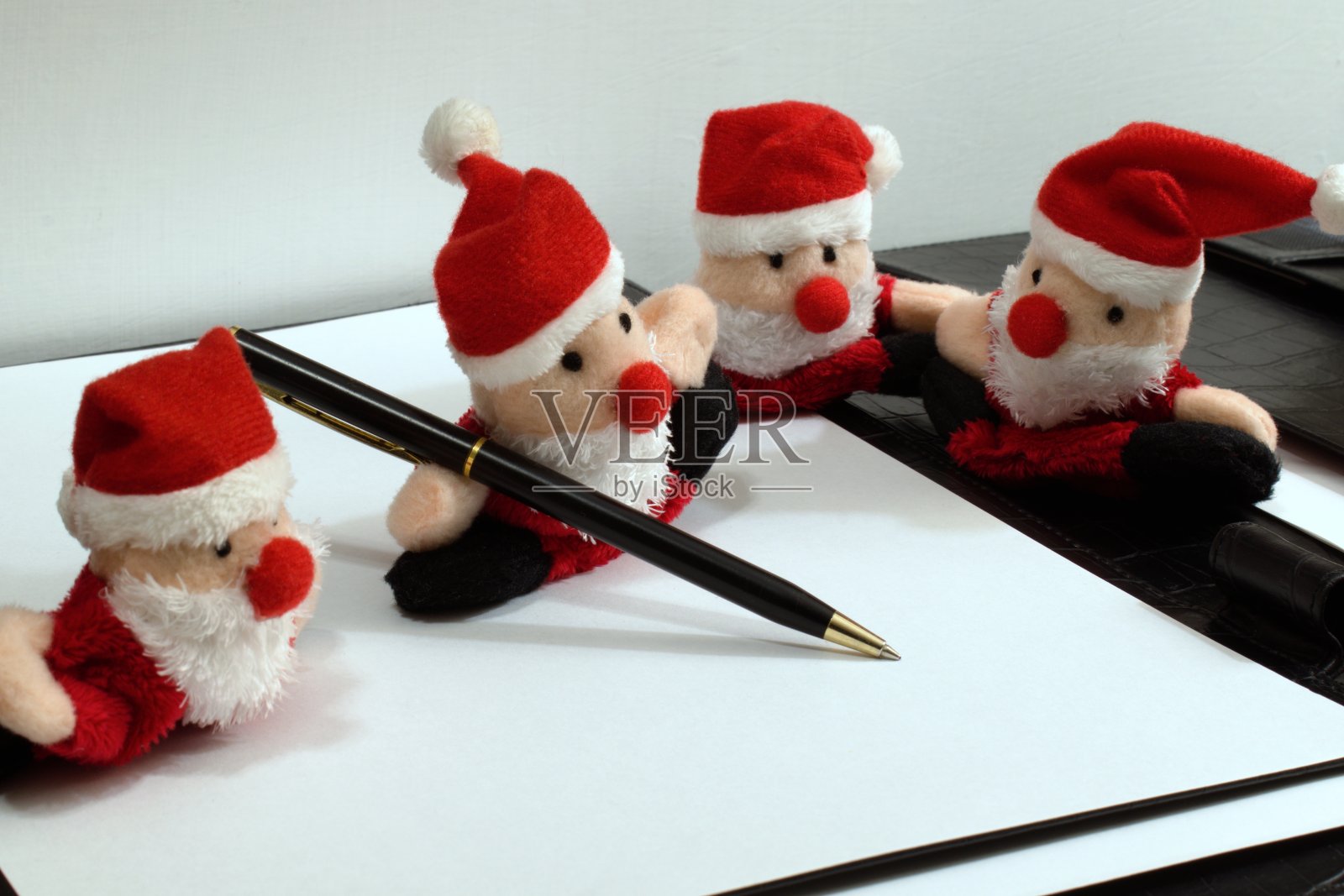四个有趣的圣诞老人玩具和圆珠笔照片摄影图片