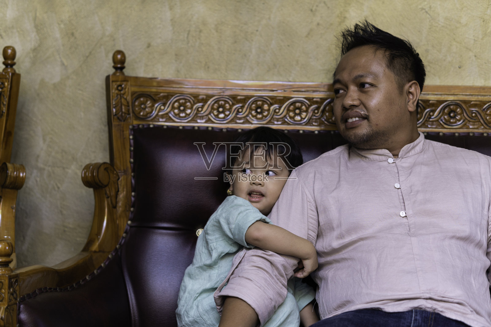 在家里，一位慈爱的父亲试图安慰他暴躁的儿子照片摄影图片