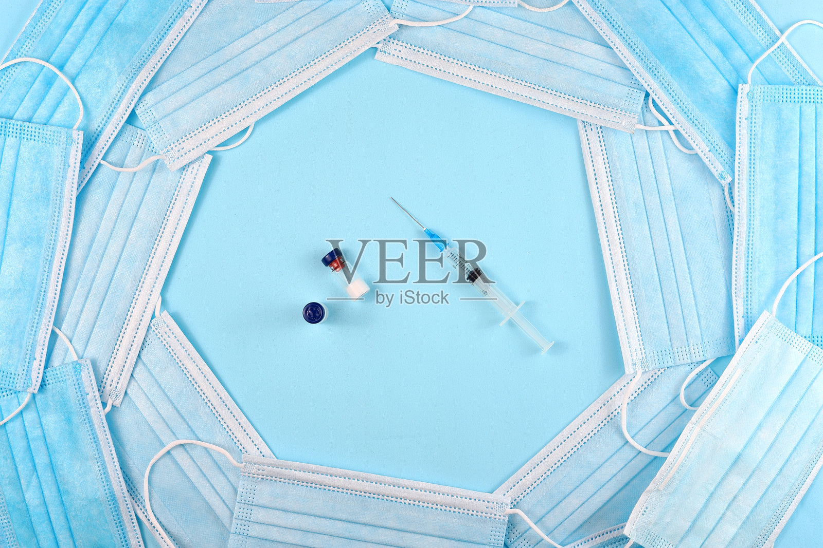 蓝色背景，装有安瓿和医用口罩的注射器。照片摄影图片