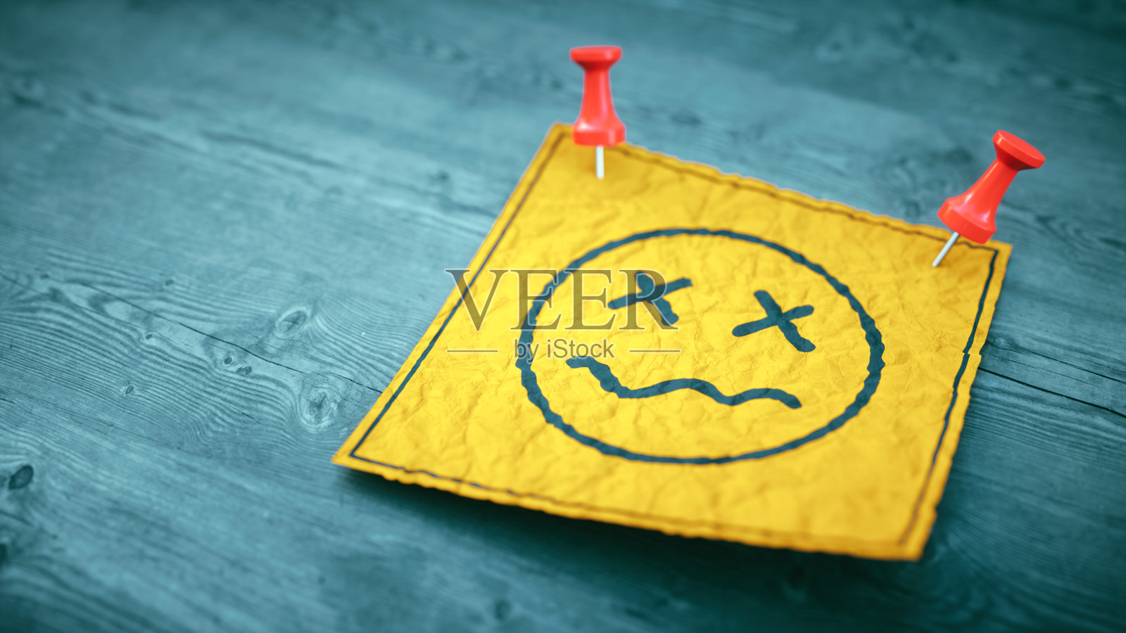 特写一张皱巴巴的纸条，一张困惑的脸钉在深色的木墙上。照片摄影图片