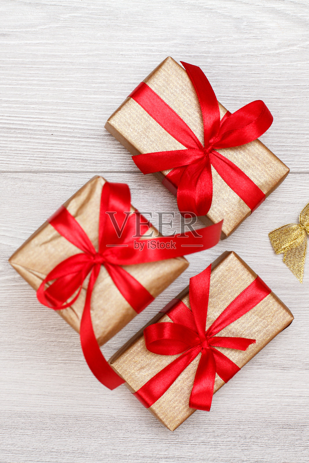 三个礼品盒在灰色的木制背景上。照片摄影图片