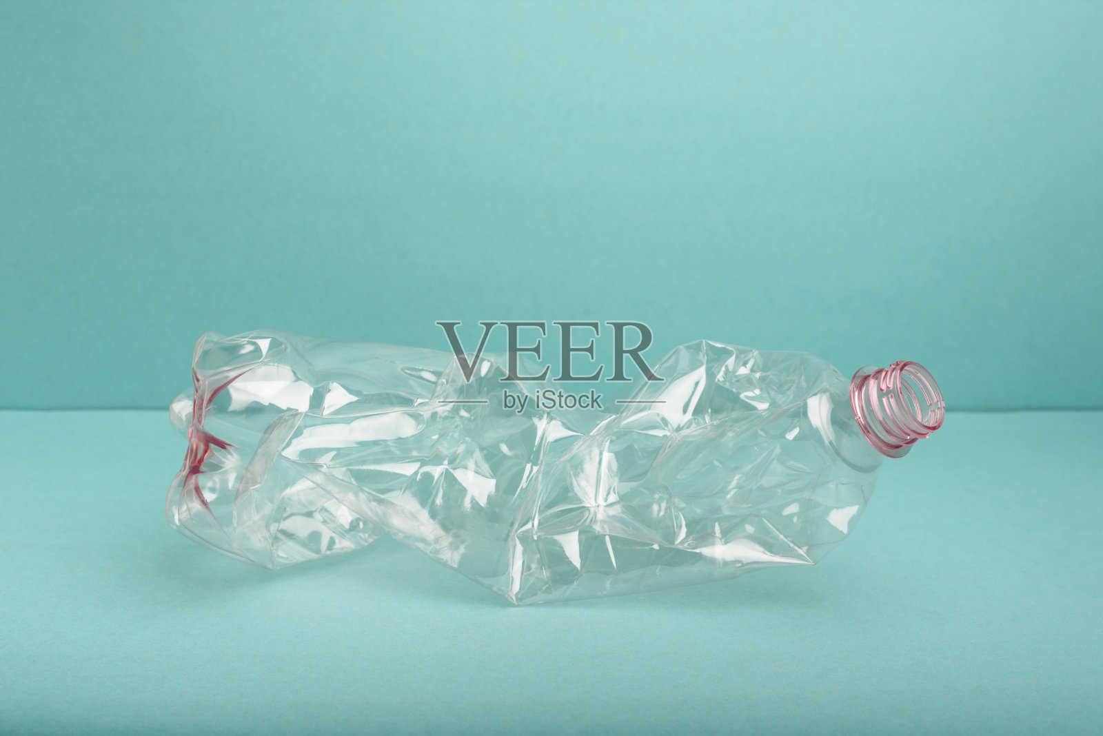 在蓝色背景上使用压碎的塑料瓶。照片摄影图片