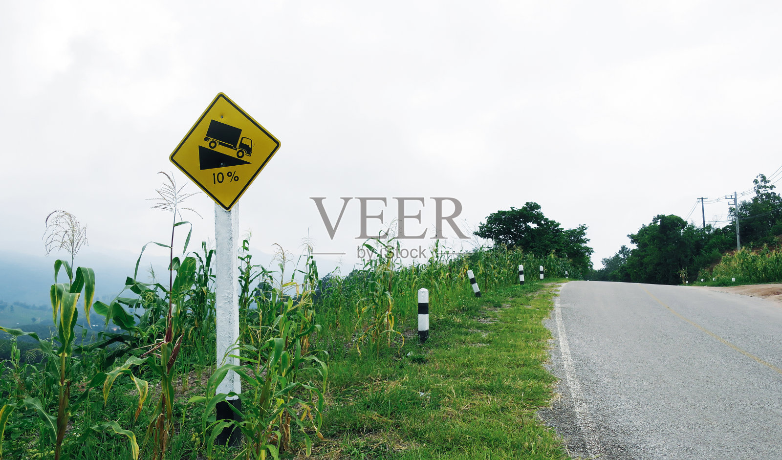 在高山路上向下倾斜交通标志照片摄影图片