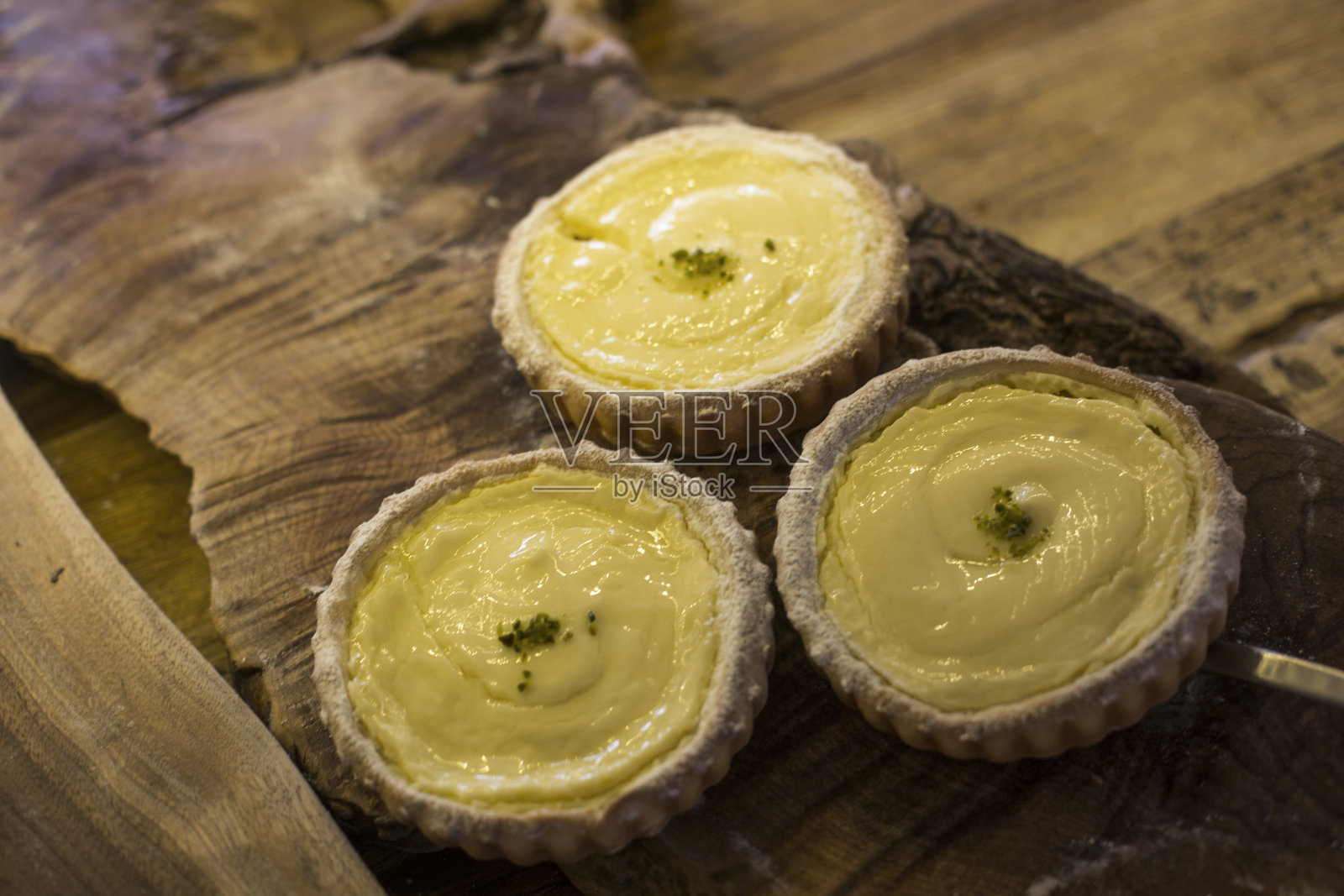 美味的葡萄牙蛋挞在木材背景。照片摄影图片