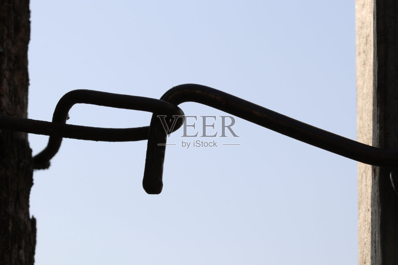 顶着天空的木门上的旧金属钩。照片摄影图片