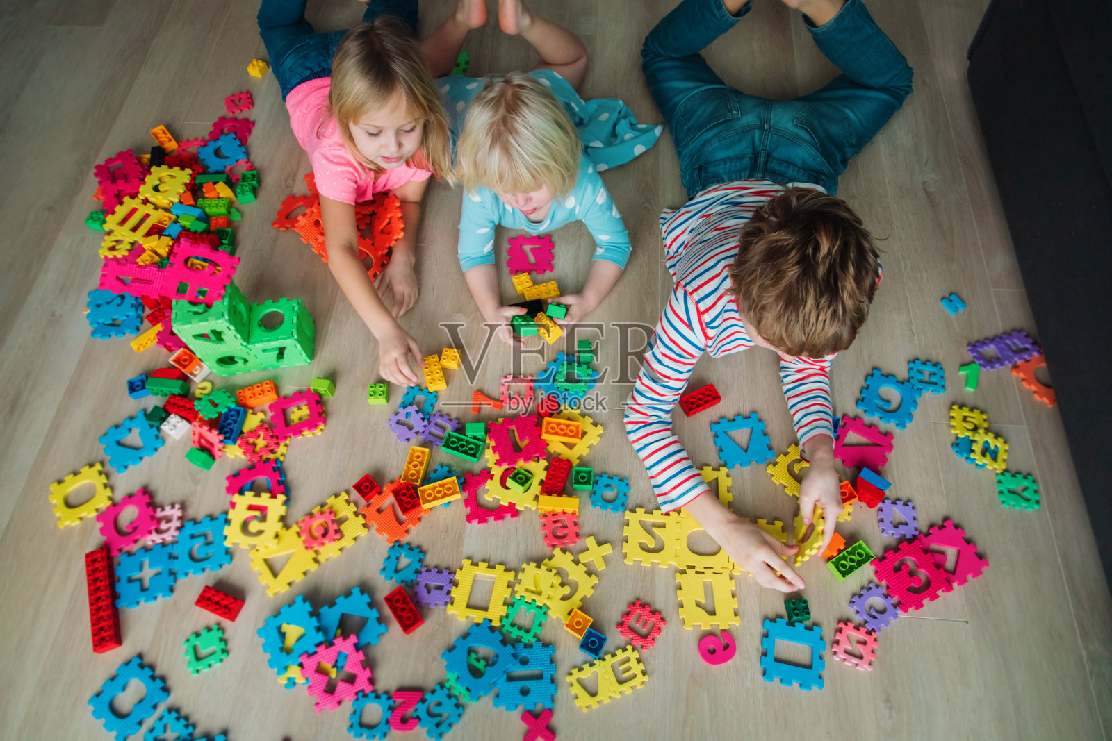孩子们在玩玩具和塑料积木，家人待在家里，照片摄影图片