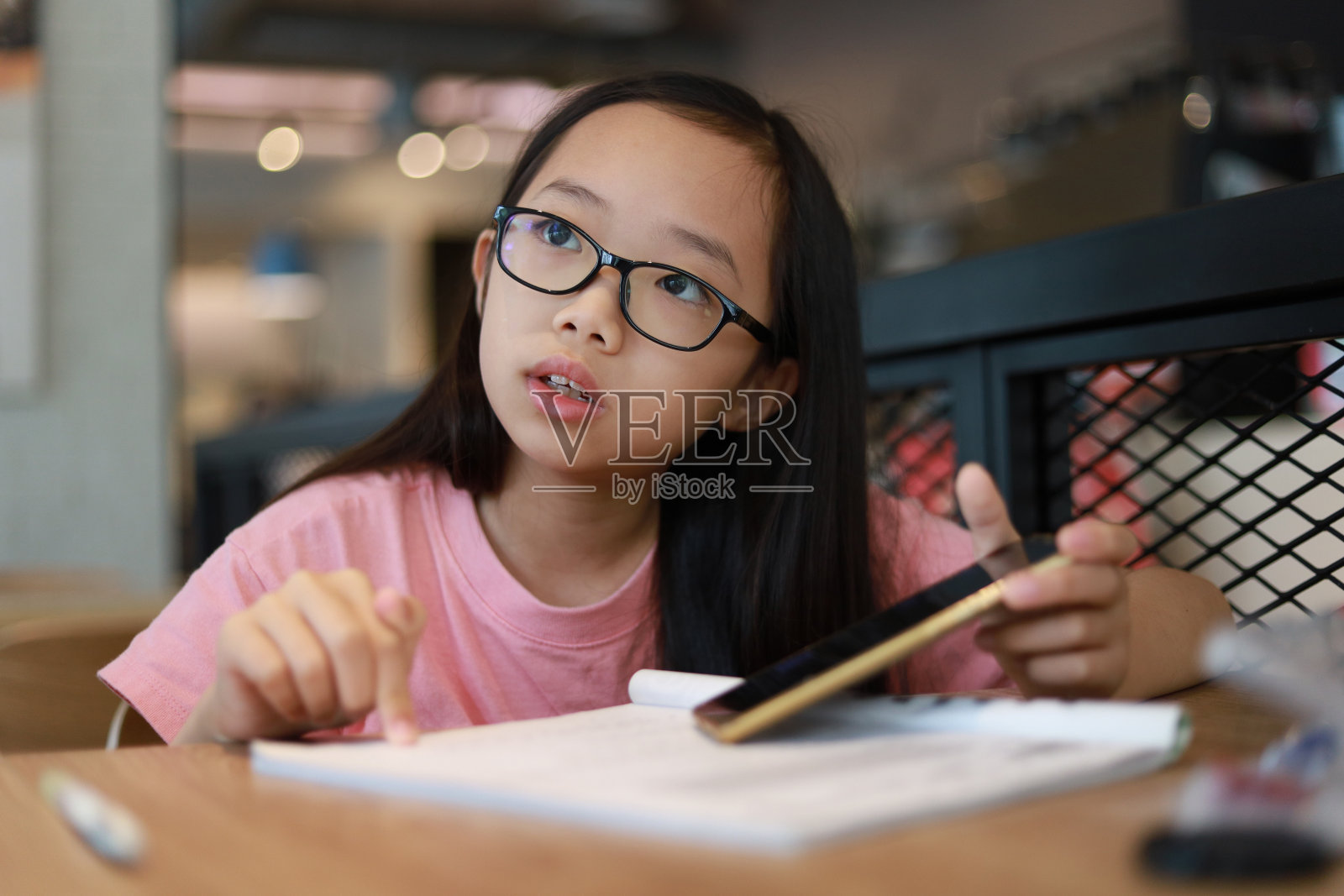 女孩在桌子旁做功课照片摄影图片
