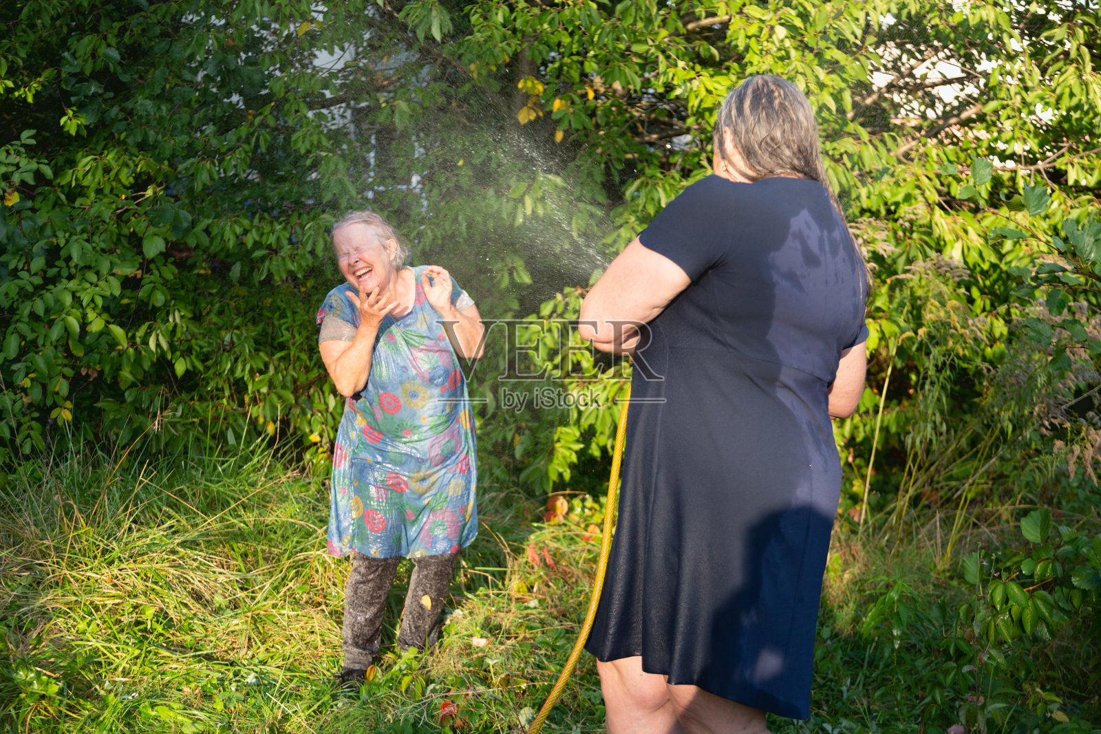 老女人在玩水仗照片摄影图片