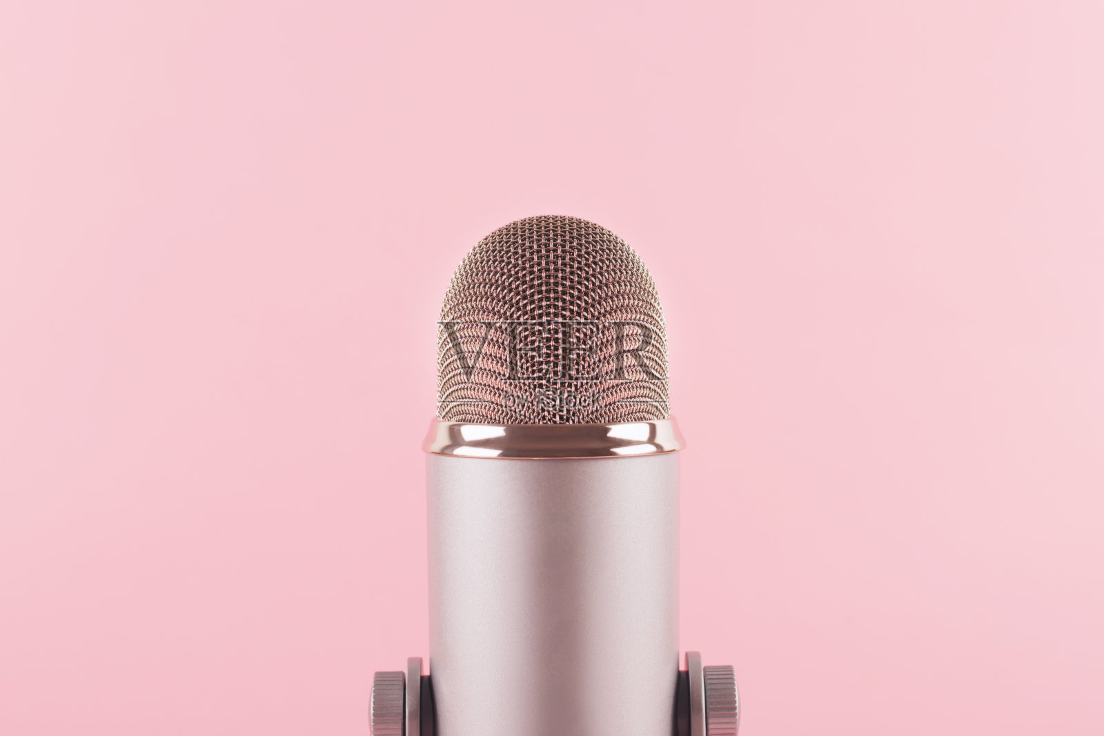 一个粉红色背景装饰的麦克风。最小的原料油。照片摄影图片