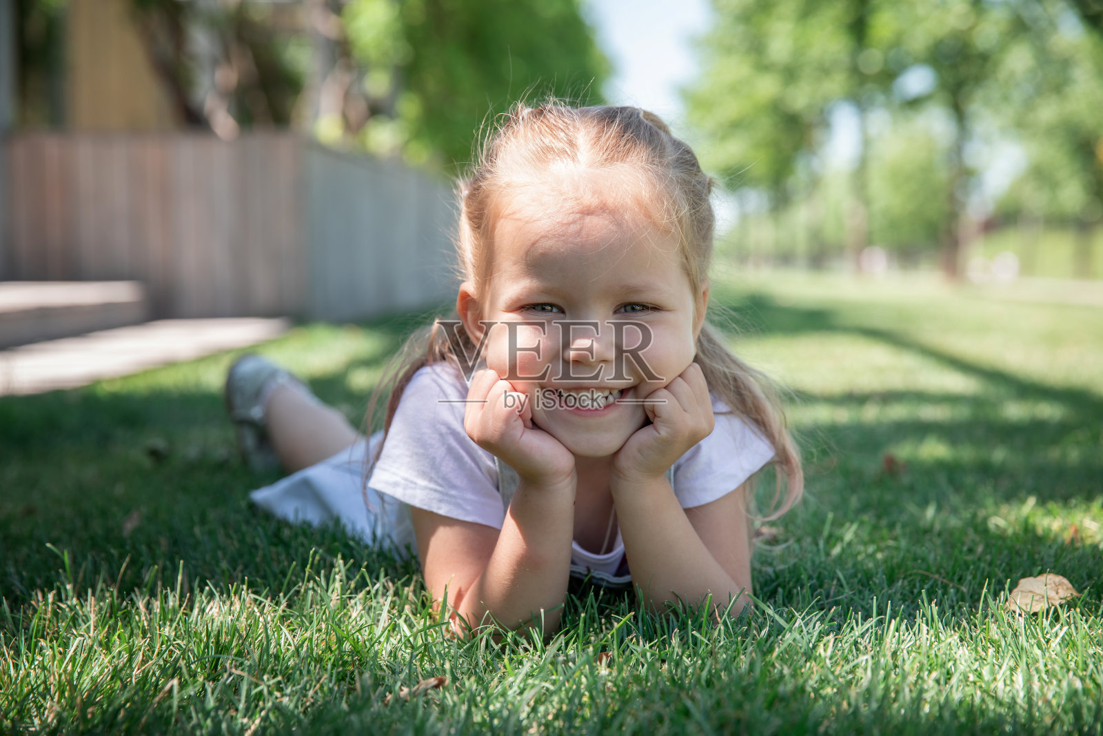一个小女孩微笑着，露出了她的牙齿。大的肖像。照片摄影图片