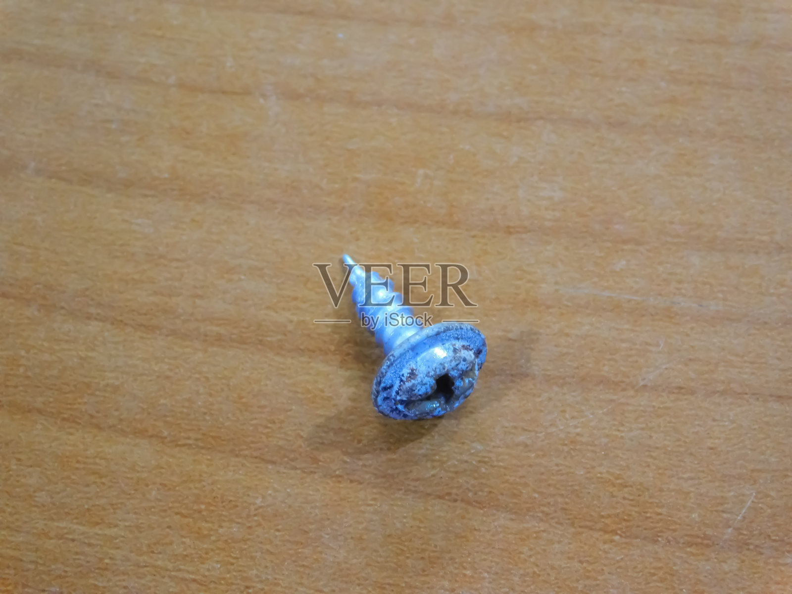 近距离观察一个螺钉隔离在木制表面照片摄影图片