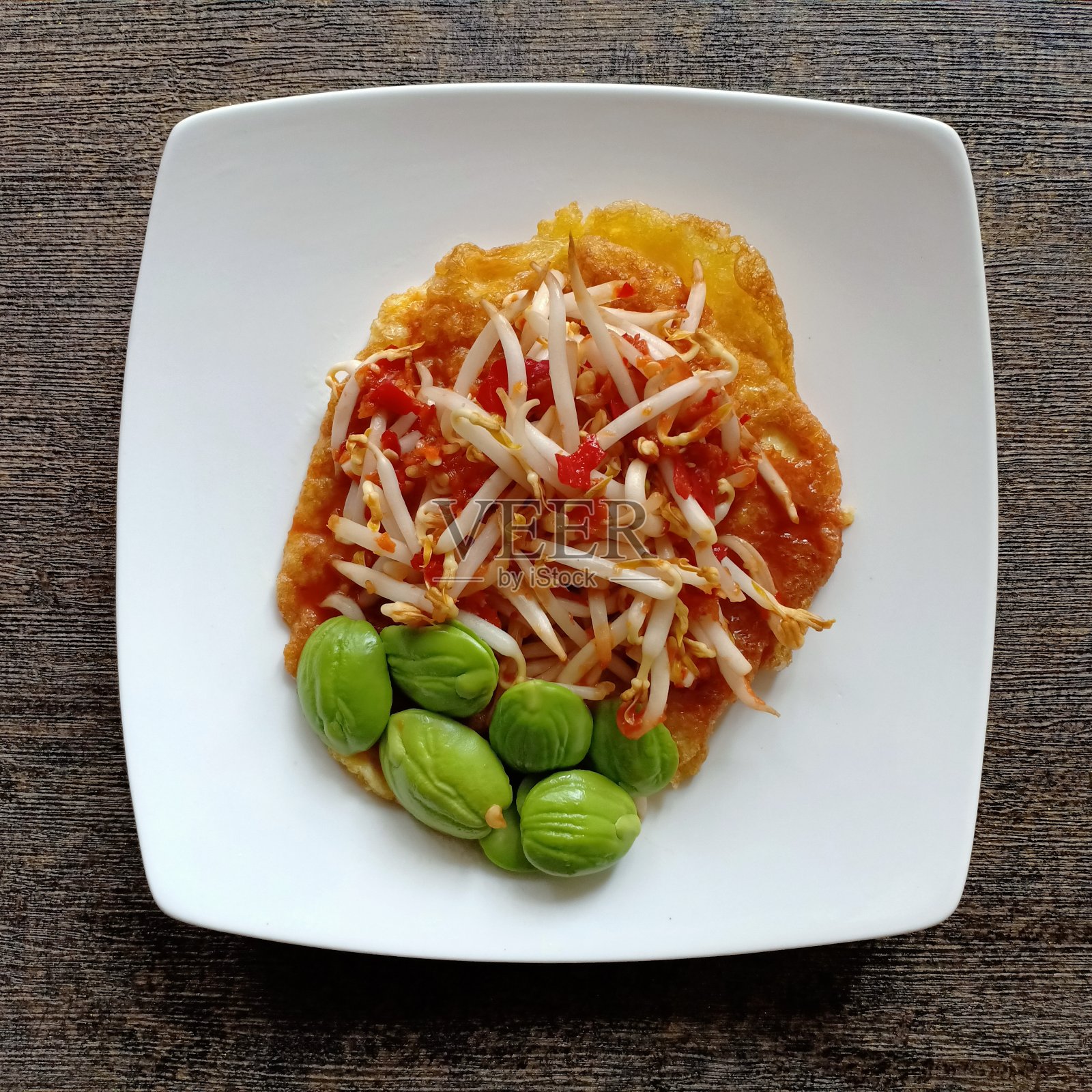 平坦的传统印尼食物。豆芽拌辣椒虾酱。配上蛋挞和蛋卷，放在白色盘子里。这是辣的食物。它可以在印尼的传统餐馆里找到照片摄影图片