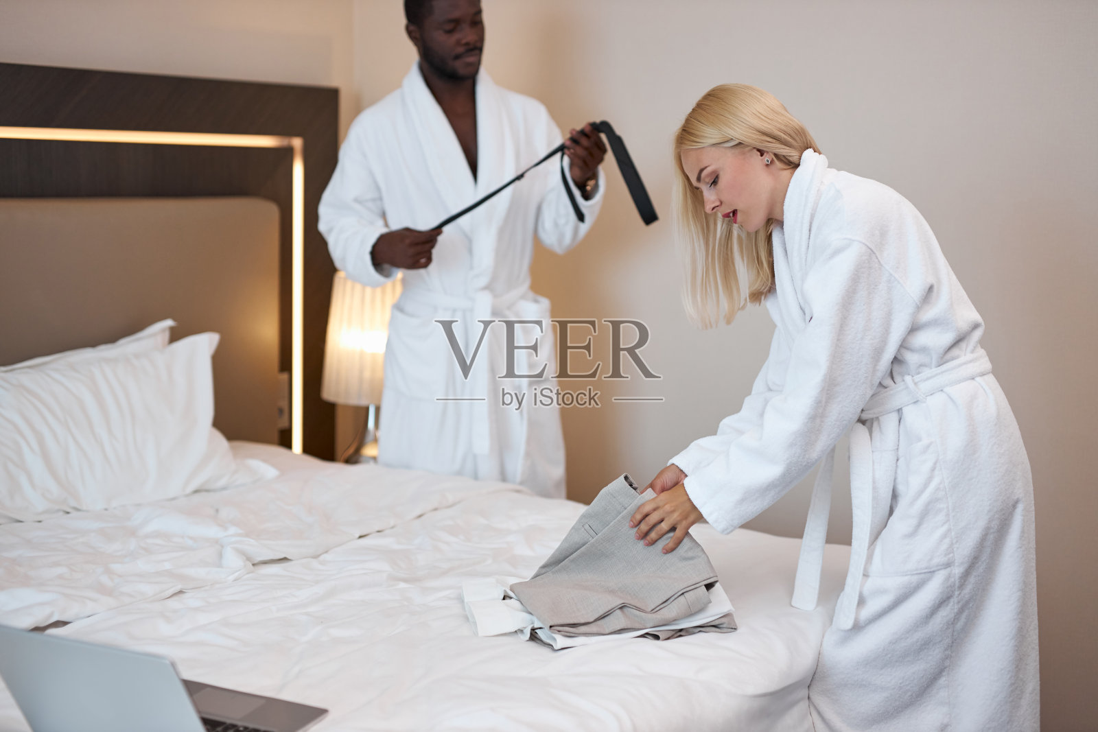 夫妇俩在酒店里摆放衣服照片摄影图片