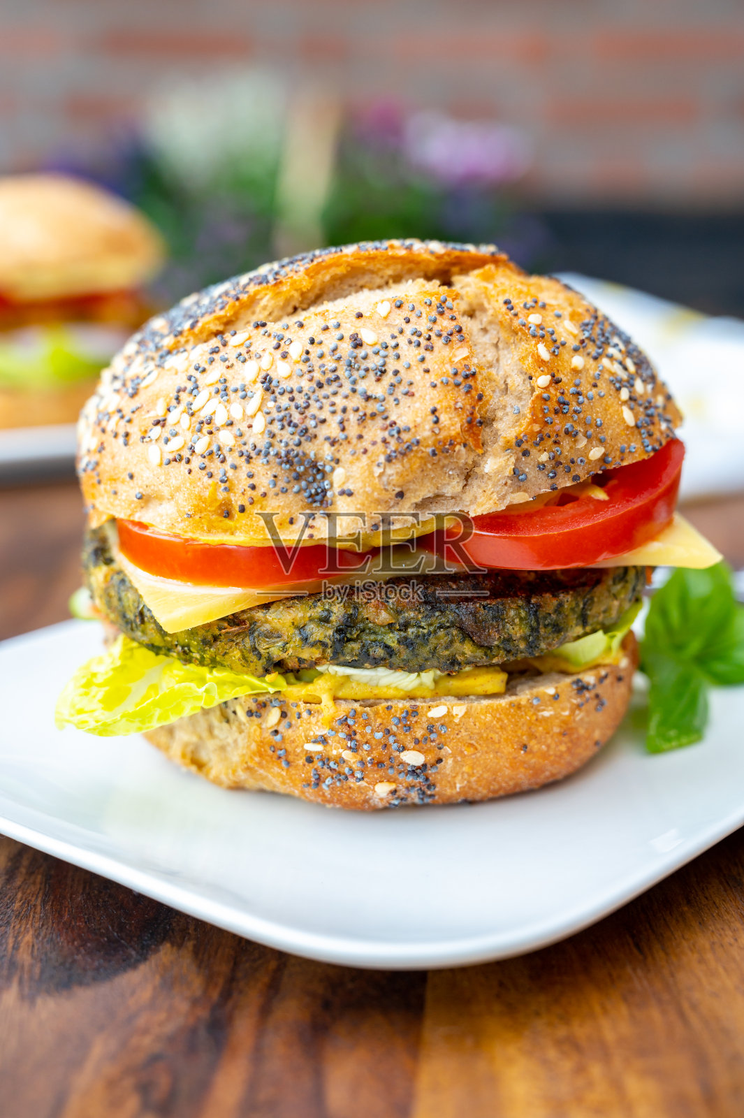 吃新鲜健康的素食汉堡配烤菠菜或南瓜汉堡，有机面包和蔬菜照片摄影图片