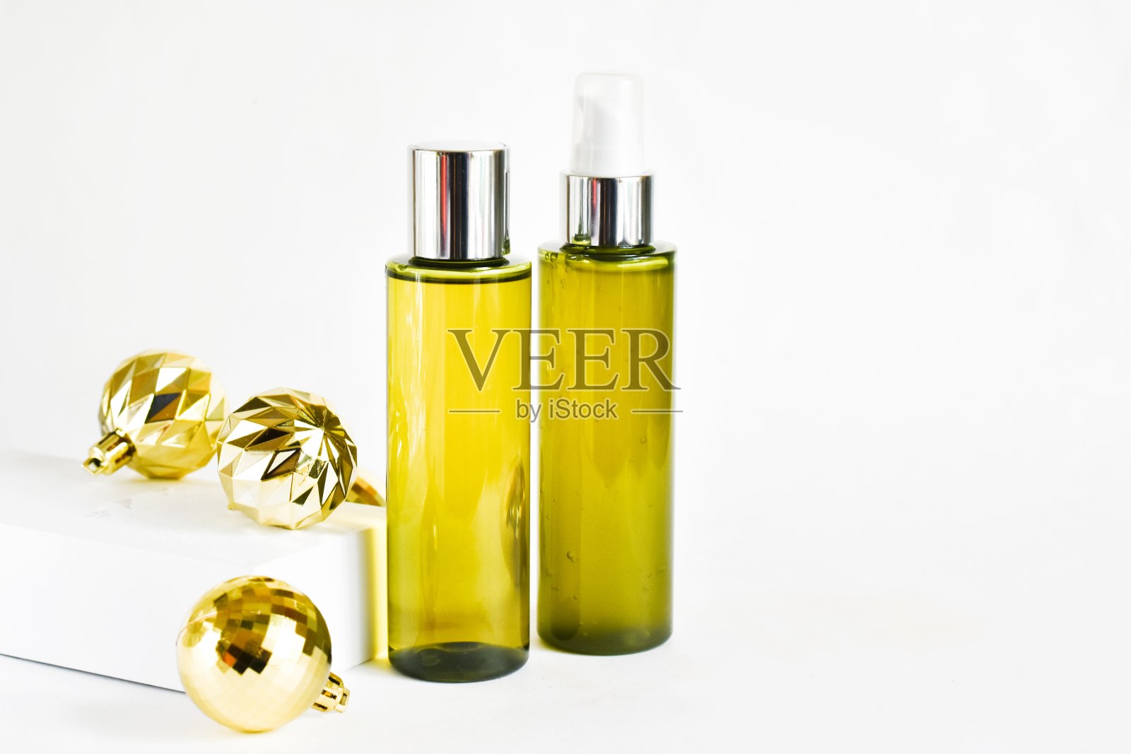 瓶子化妆品产品在白色的背景与金色的圣诞球。SPA天然美容产品。天然美容产品概念。 副本的空间。照片摄影图片