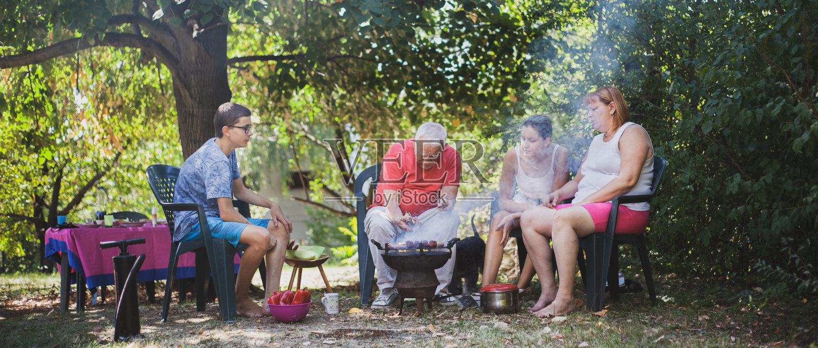 大家庭在后院享受准备烧烤的乐趣照片摄影图片