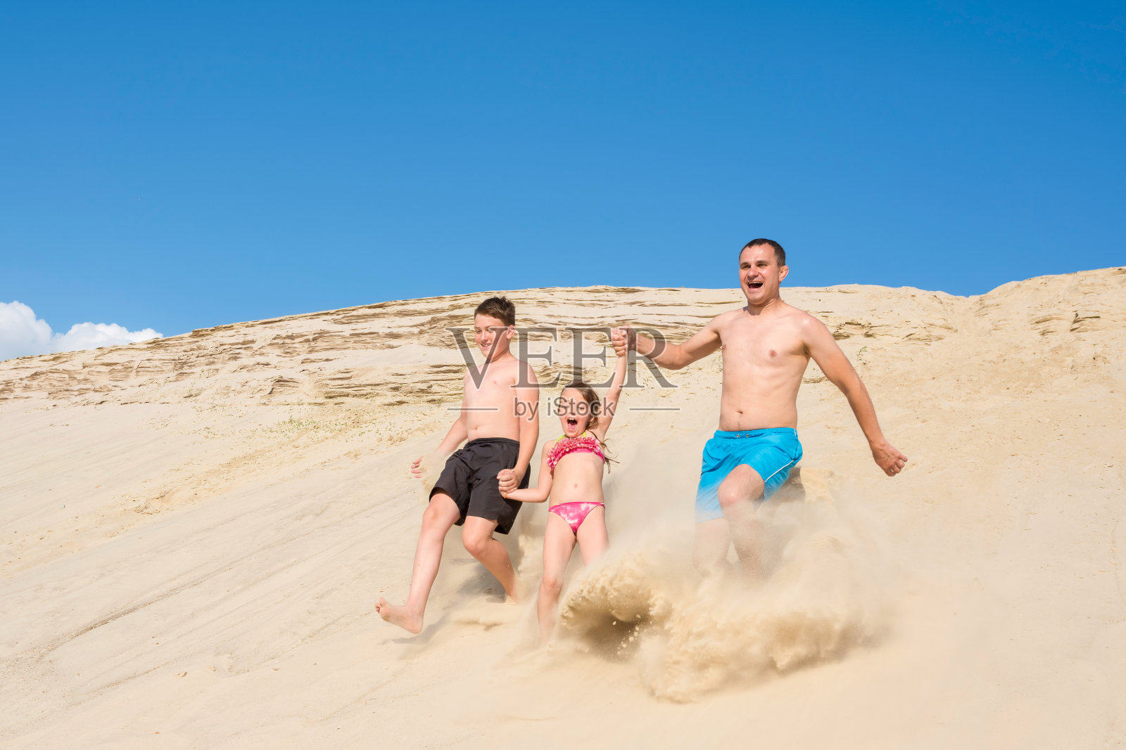 快乐的一家人在沙滩上欢快地奔跑。家庭户外运动游戏。积极健康的生活方式理念。照片摄影图片