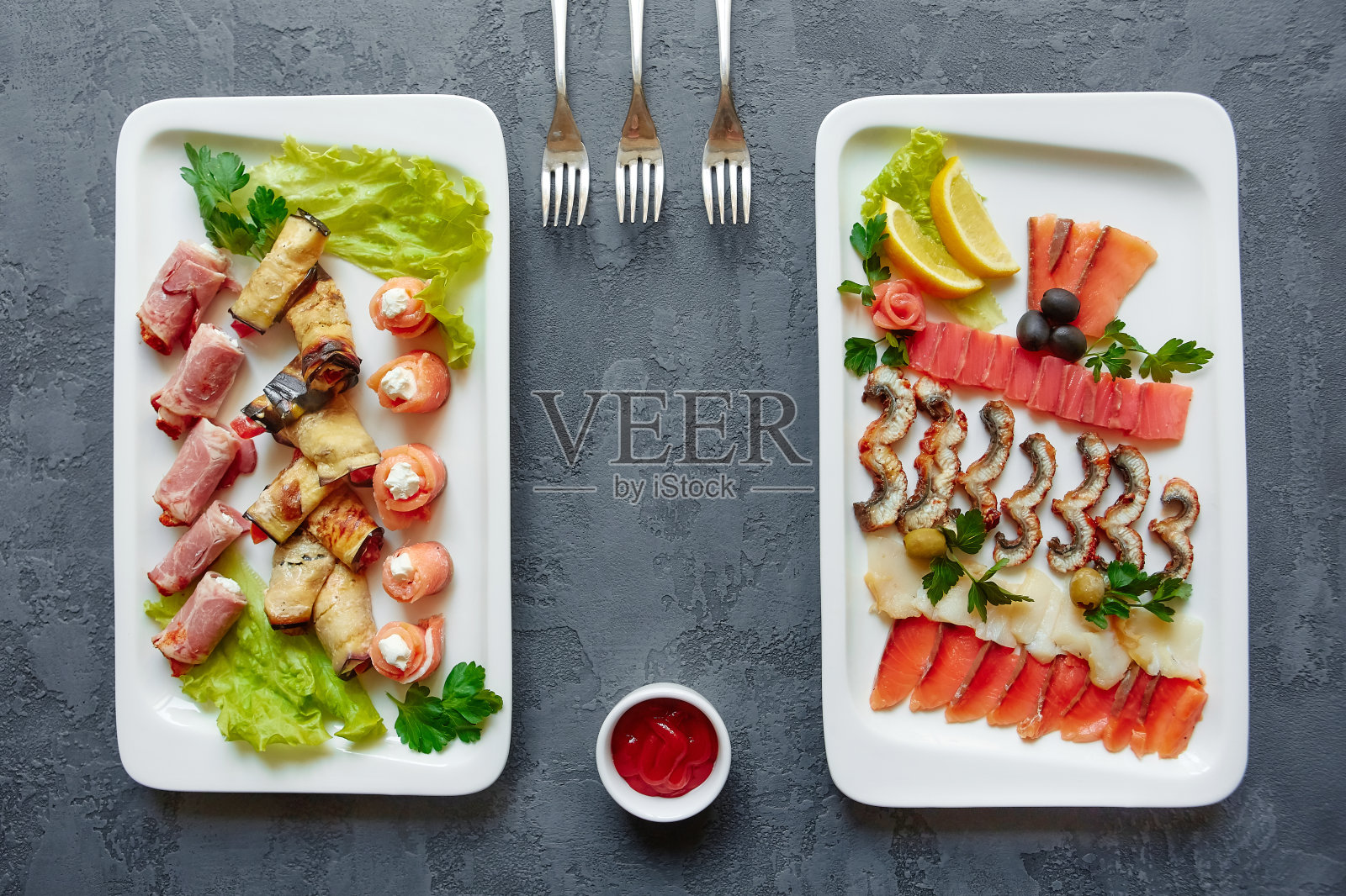 什锦鱼，红鱼点心，茄子和火腿卷塞满奶酪和香草在白色的盘子在灰色的背景照片摄影图片