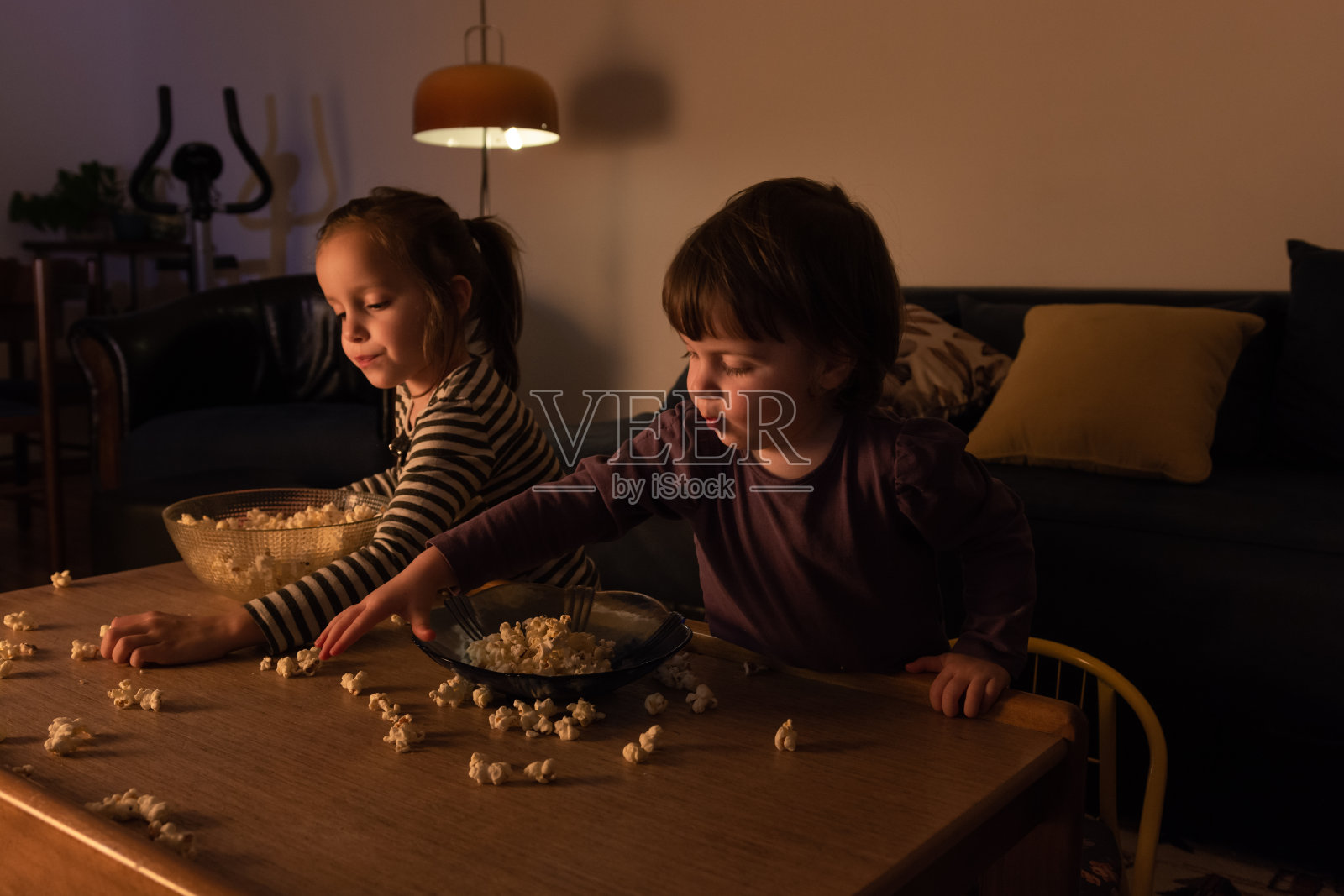 孩子们坐在客厅里吃爆米花照片摄影图片