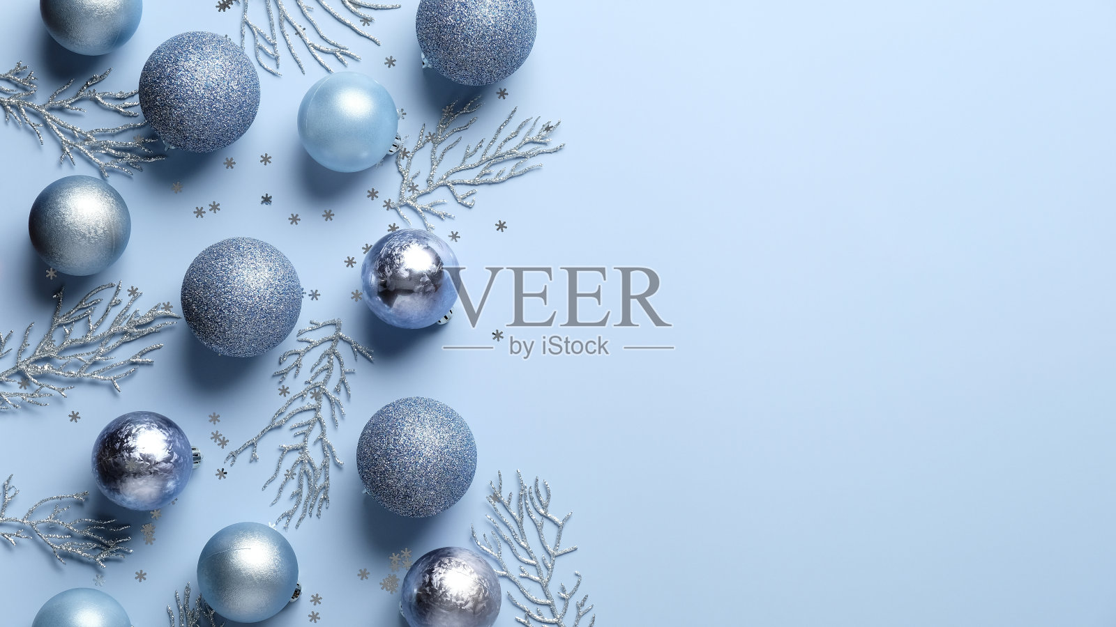 圣诞平铺构图。蓝色和银色的球，装饰品，淡蓝色背景上的五彩纸屑。优雅,最小的风格。圣诞贺卡模板，横幅模型。照片摄影图片