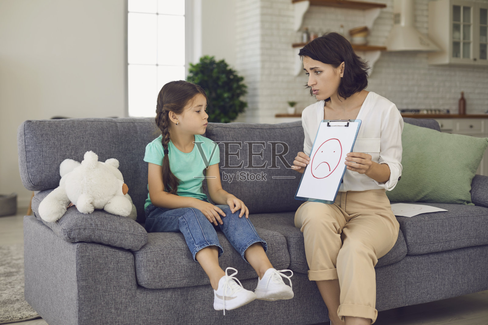 小女孩看着儿童心理学家给她展示的图片照片摄影图片