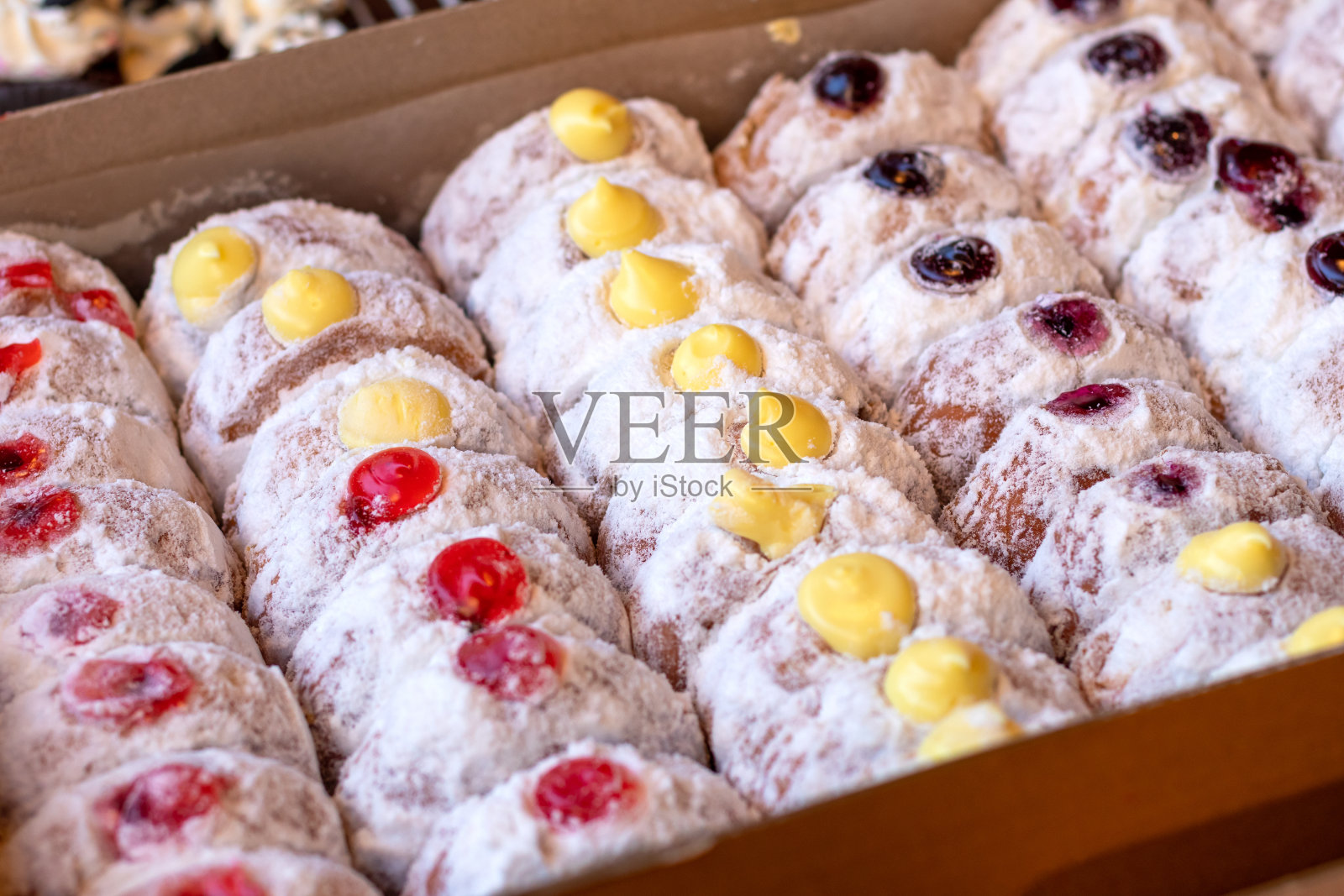 许多撒了面粉的甜甜圈。照片摄影图片