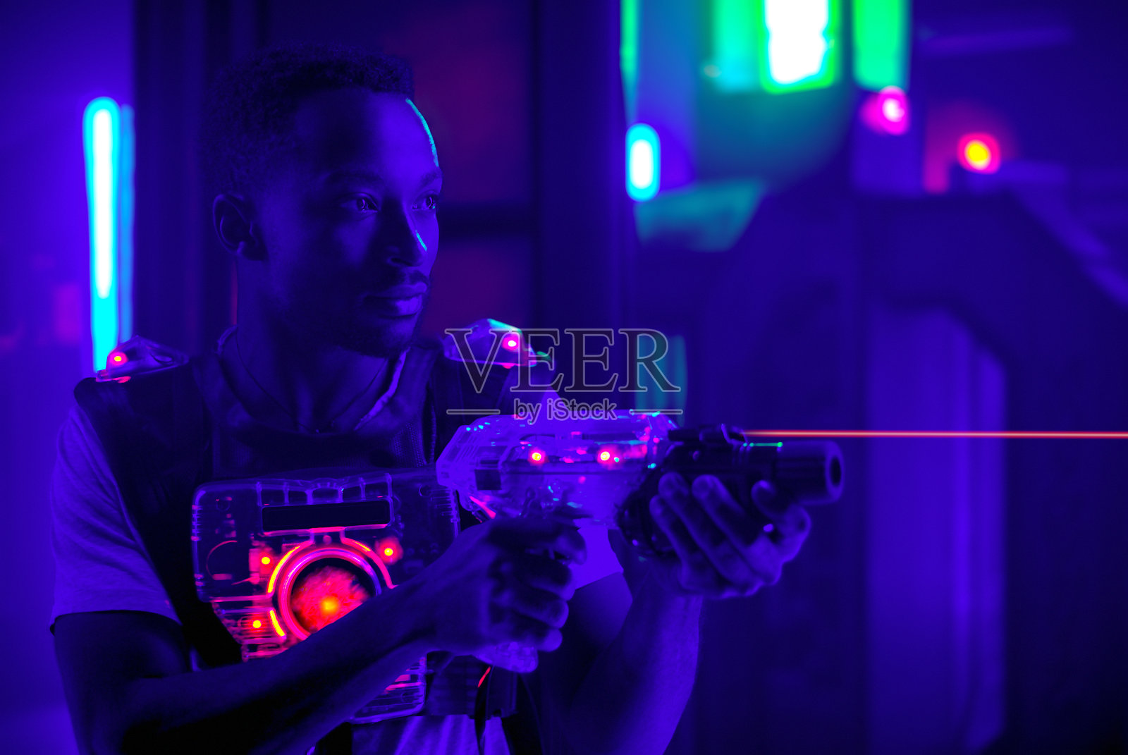 激光枪战游戏玩家射击光枪科幻背心在黑光照片摄影图片