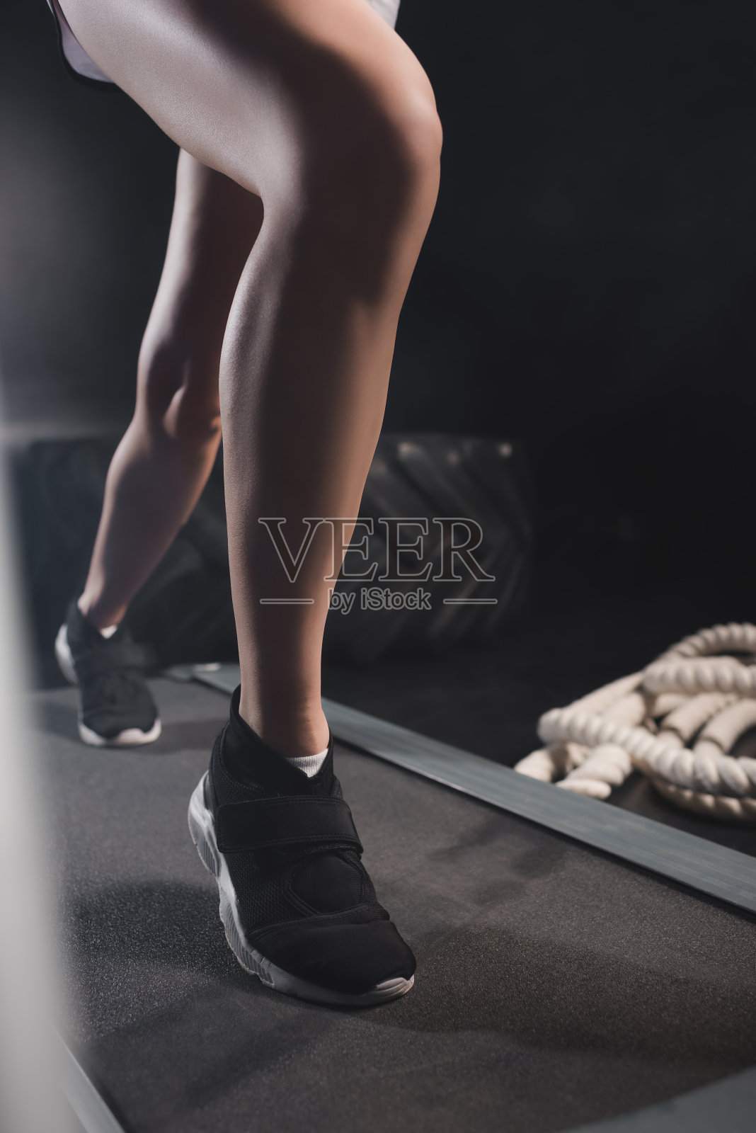 女运动员在运动中心的跑步机上跑步照片摄影图片