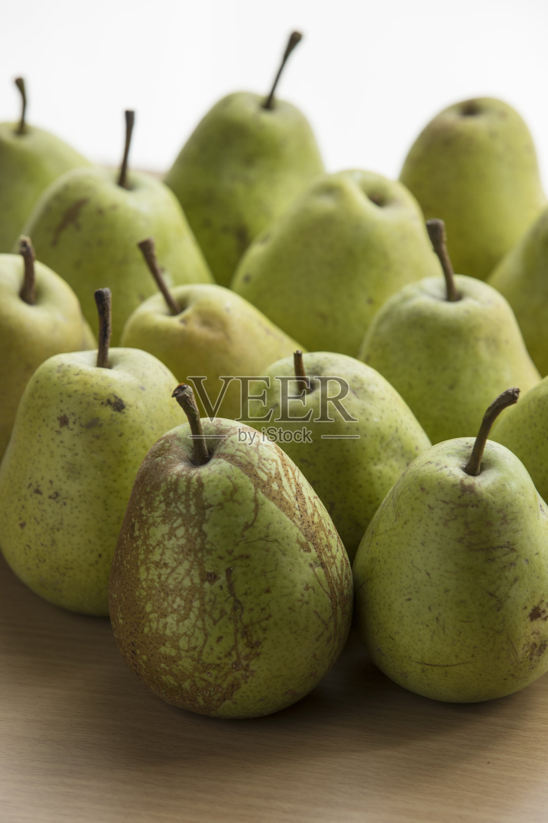 背光近距离的一堆巴特利特梨在桌面上。照片摄影图片