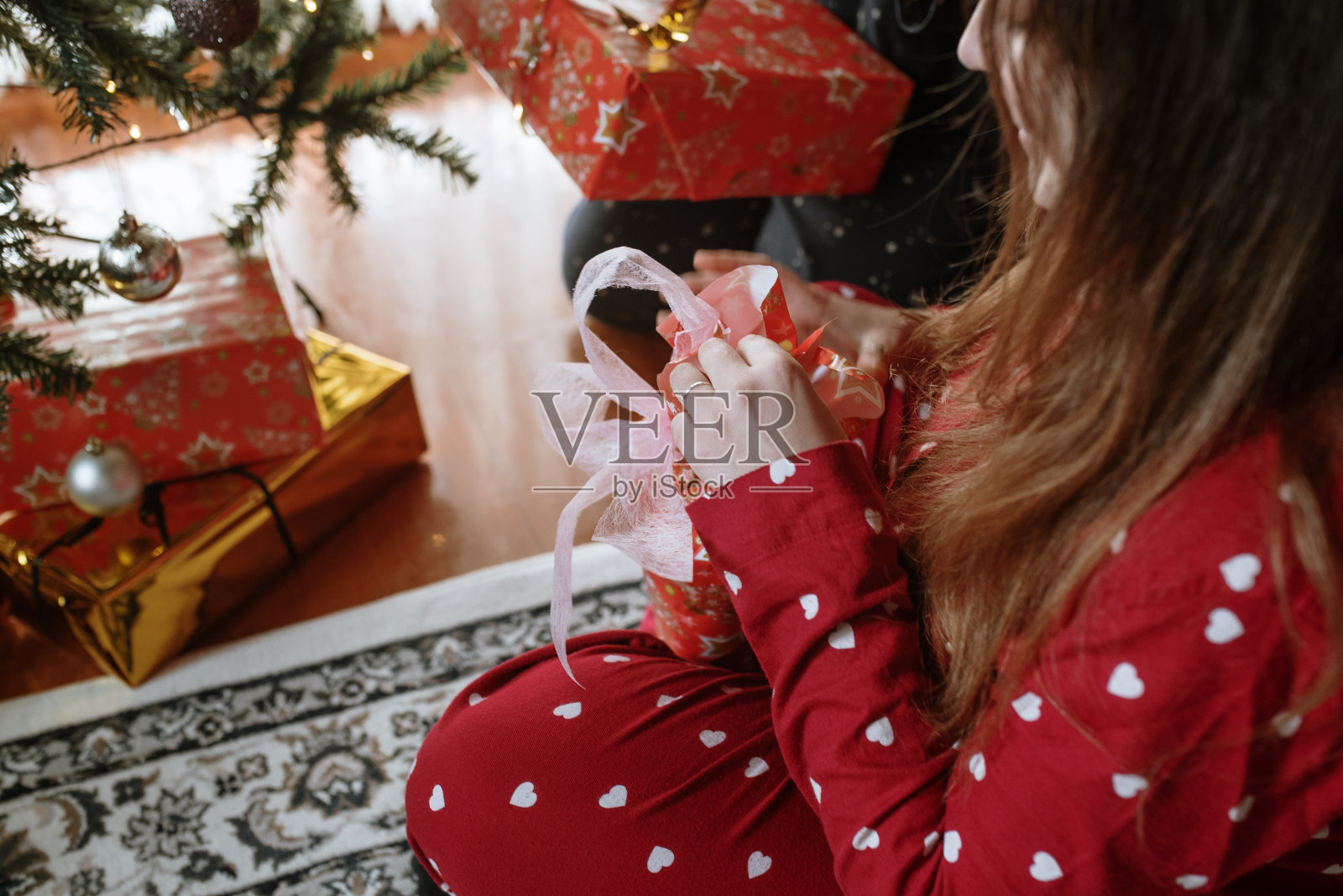 年轻的双胞胎姐妹打开圣诞礼物照片摄影图片