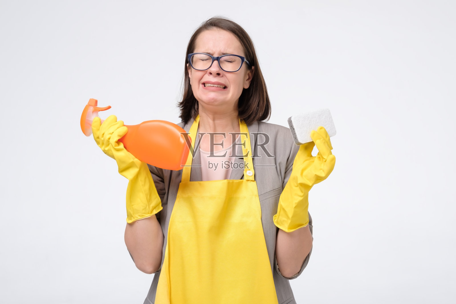 疲惫不堪的女人拿着毛巾和洗洁精，哭了照片摄影图片