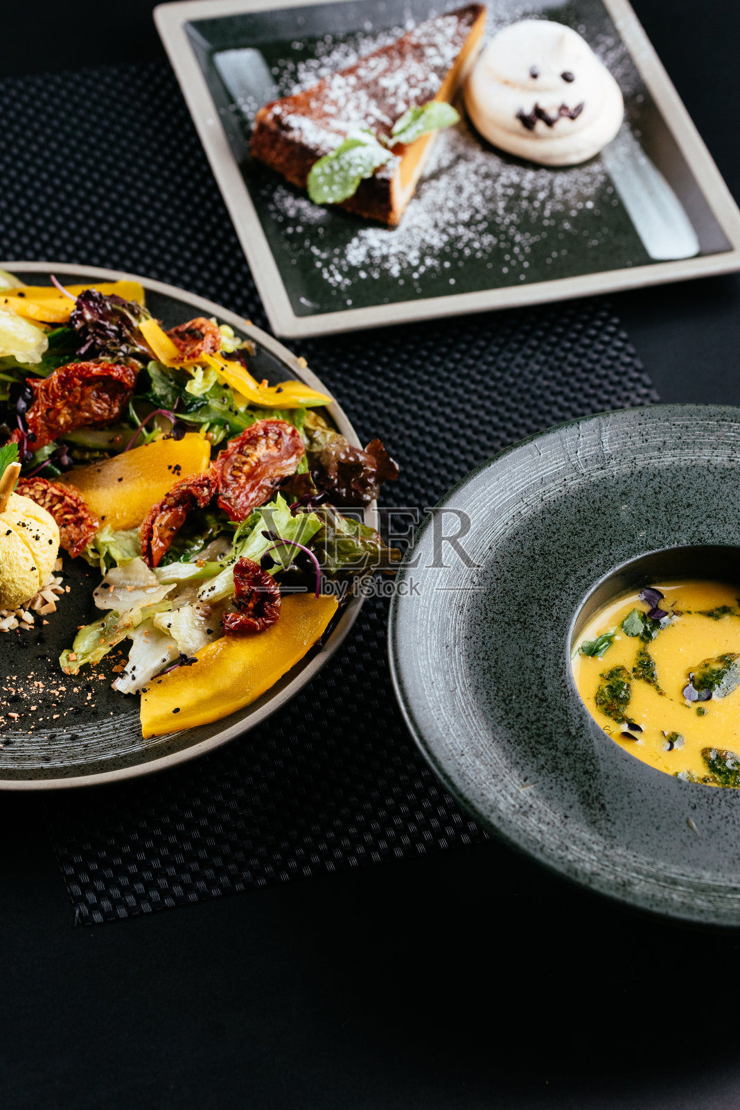 秋天的南瓜沙拉和晒干的番茄在黑色的背上照片摄影图片