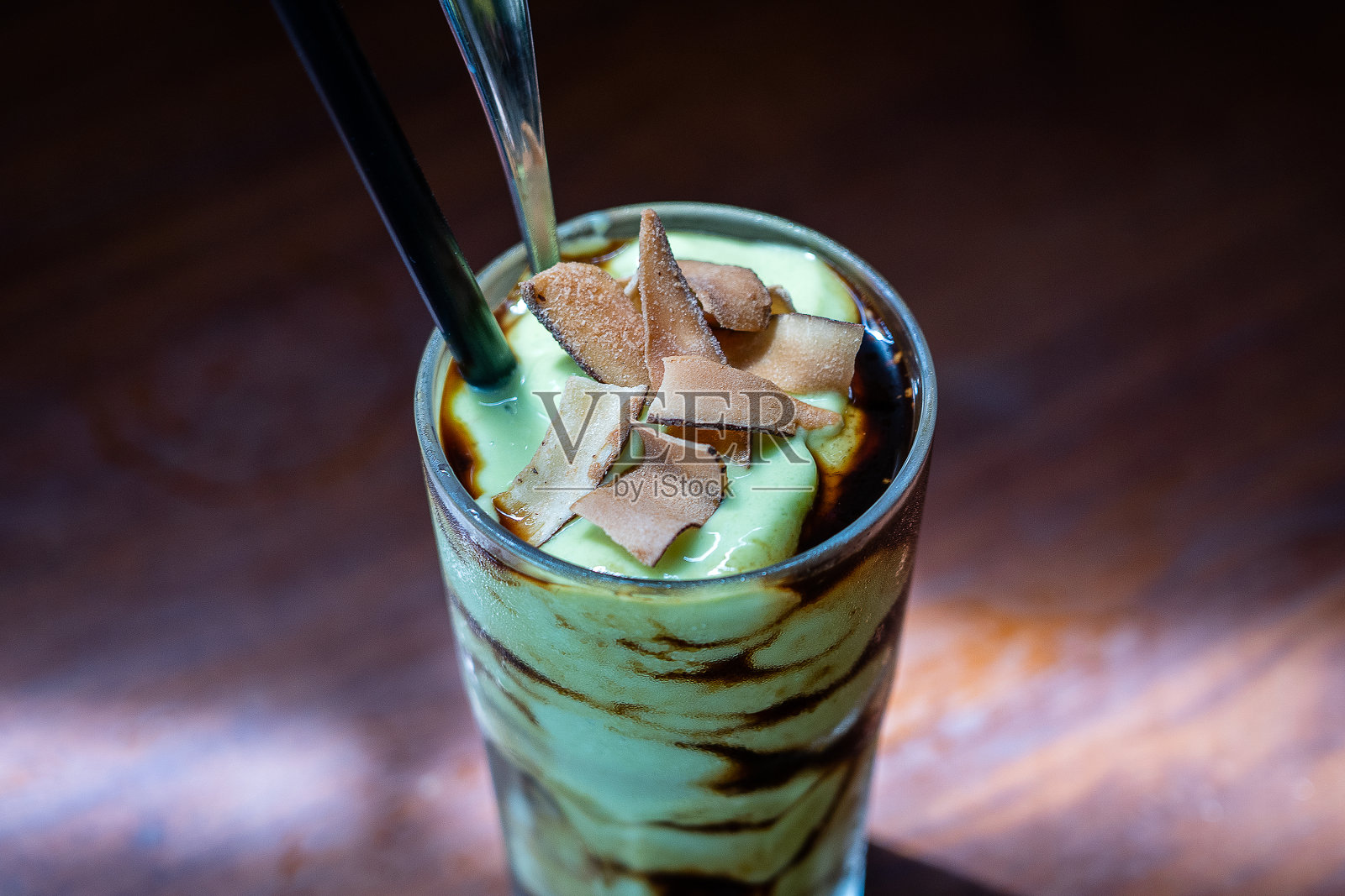 越南餐馆里的绿鳄梨冰沙加黑咖啡和椰子片，特写照片摄影图片