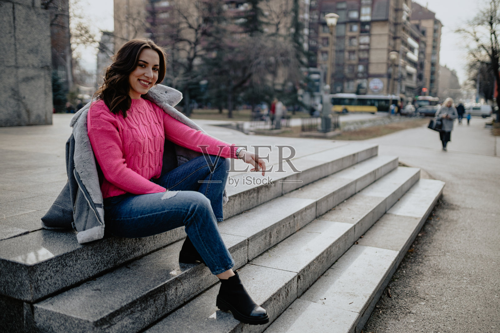 秋日里，一个穿着随便的女人坐在街上照片摄影图片
