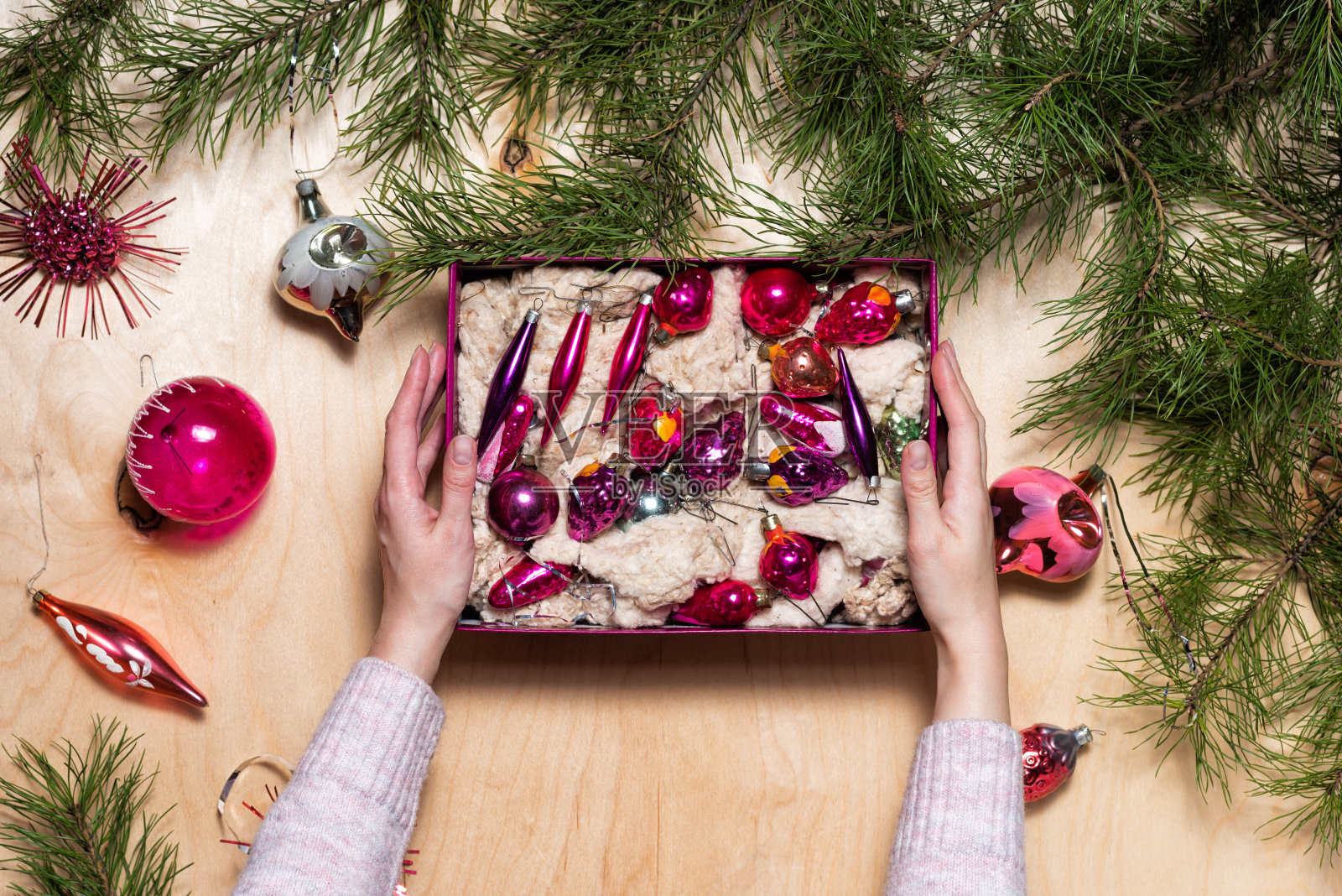 女人手里拿着一盒古老的圣诞树装饰品照片摄影图片