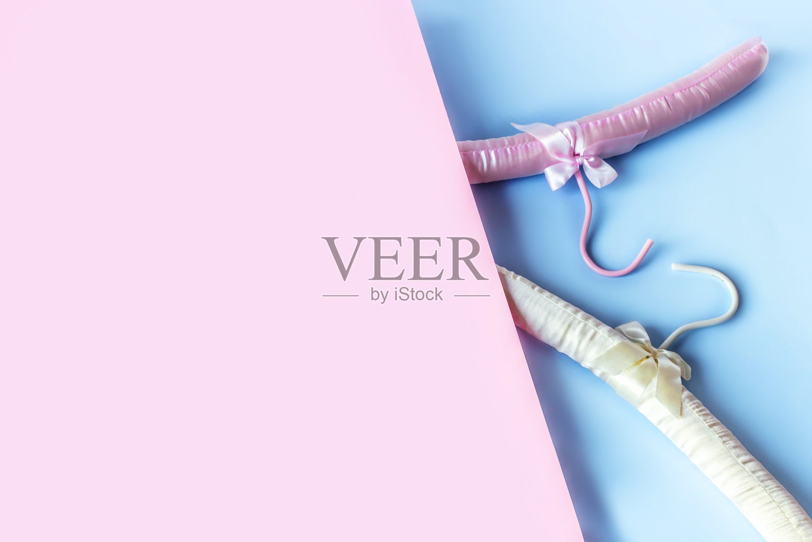 空衣架，淡粉色和蓝色背景，有拷贝空间。销售和购物概念。照片摄影图片