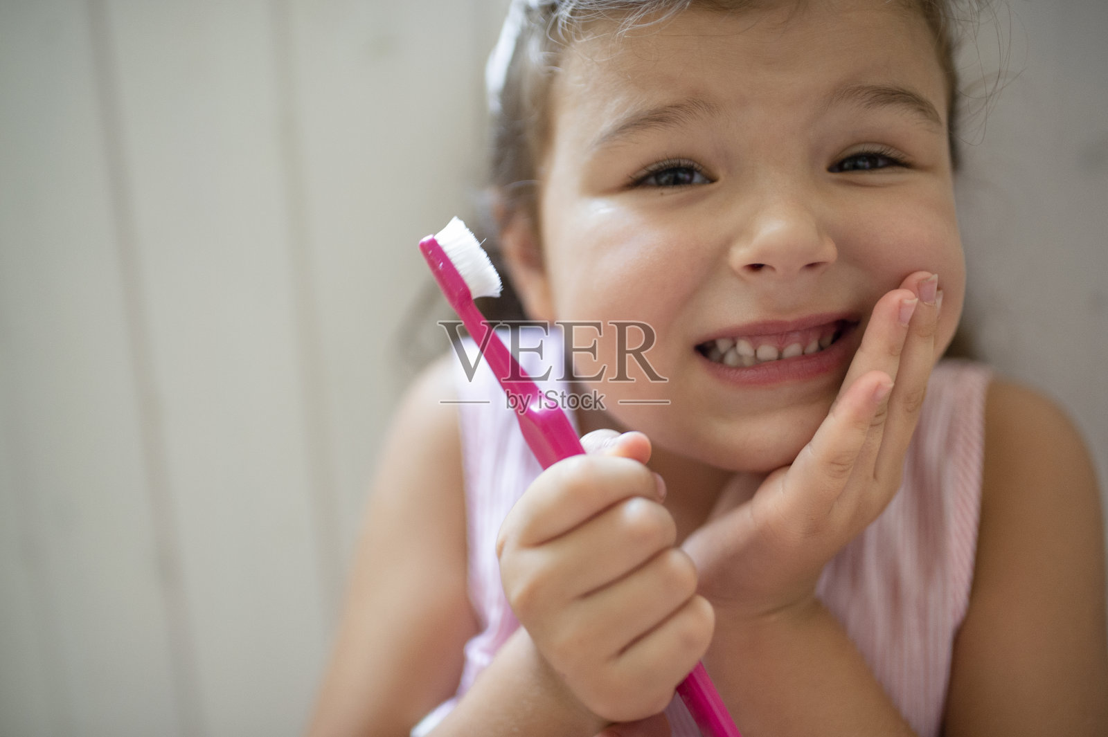 正面肖像的担心小女孩室内，失去乳牙。照片摄影图片