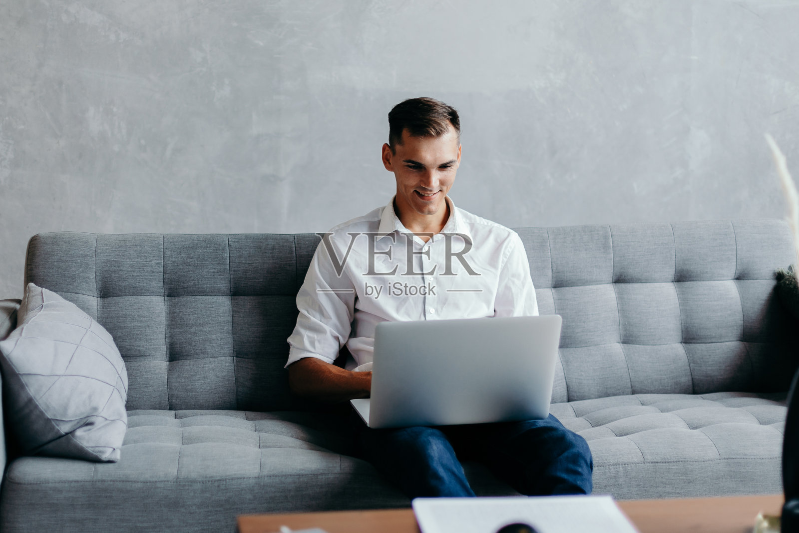 一位年轻的企业家在他的公寓里用笔记本电脑工作照片摄影图片