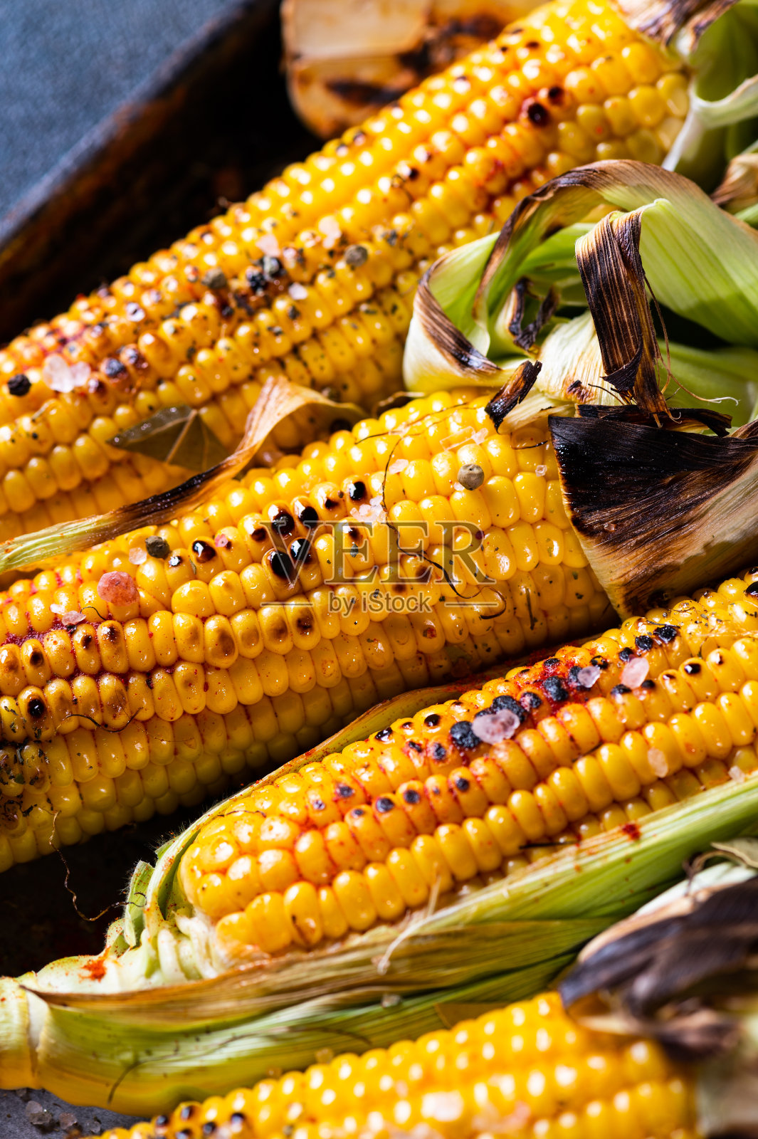 烤玉米棒，加盐，辣椒粉和黄油。有机食品，素食餐。烧烤,烧烤。玉米、甜玉米、谷物。有机食品，健康营养。照片摄影图片